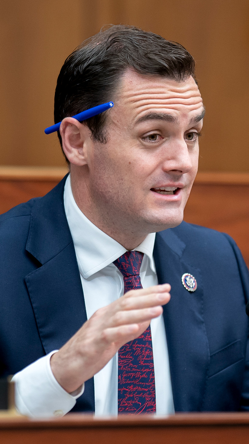 Mike Gallagher in a suit and tie at a panel hearing in Congress