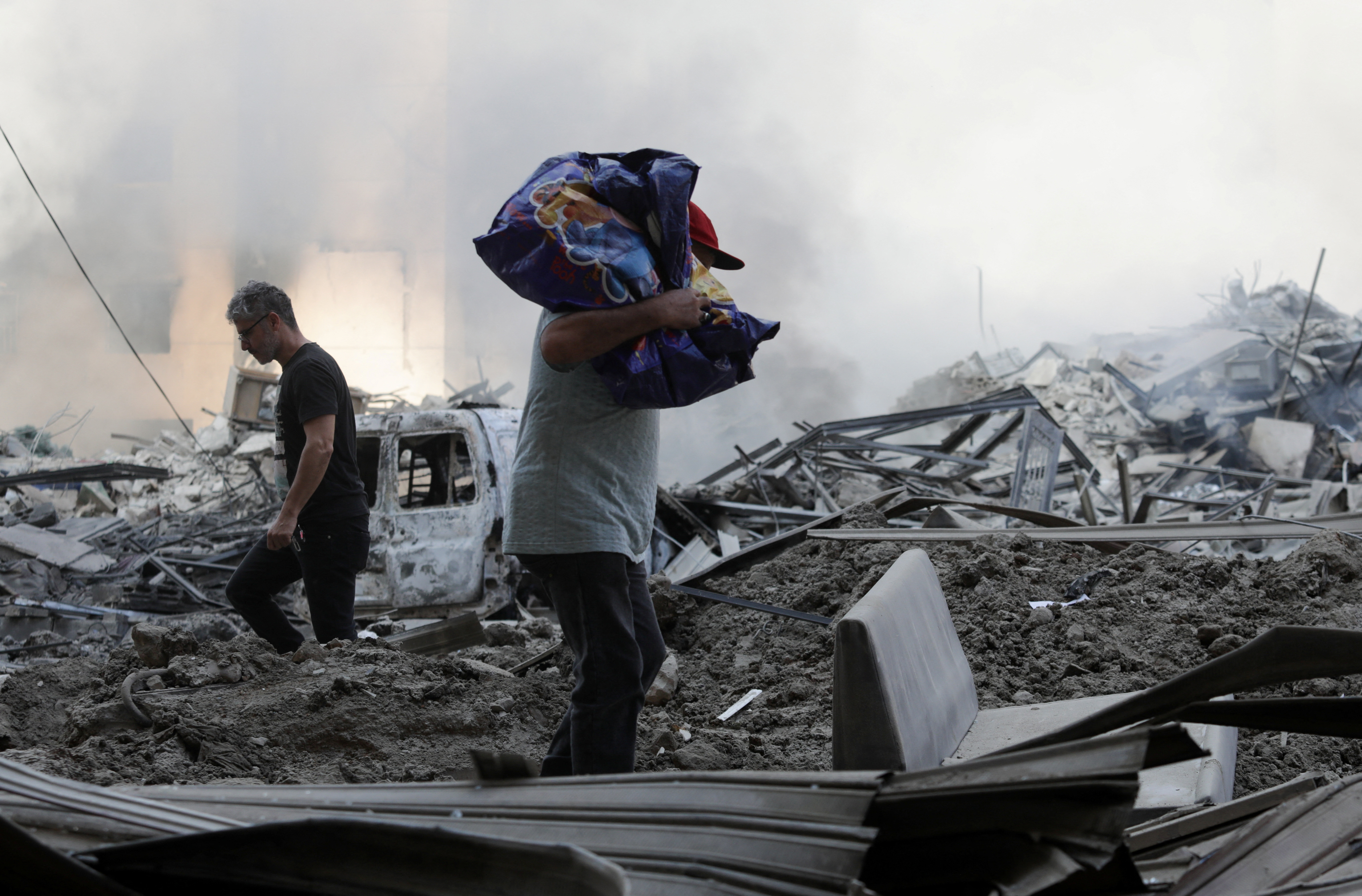 People walk over rubble following an Israeli airstrike in Beirut