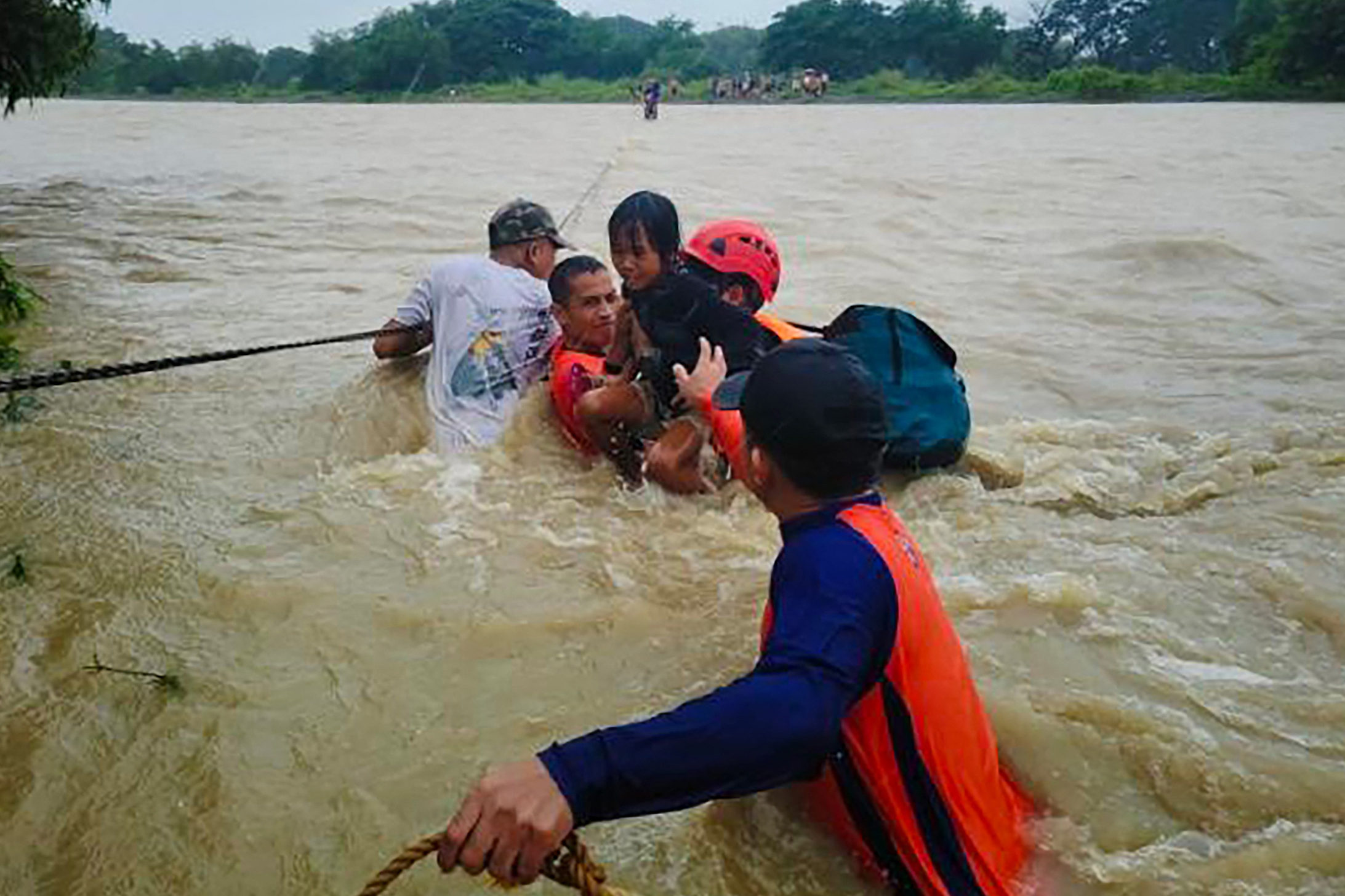 TOPSHOT - This handout photo taken on September 14, 2024 and received from the Philippine Coast Guard (PCG) on September 15 shows coast guard personnel and rescue workers evacuating residents as heavy rains triggered flooding brought by Tropical Storm Bebinca in Rizal town, Occidental Mindoro province. (Photo by Handout / Philippine Coast Guard (PCG) / AFP) / -----EDITORS NOTE --- RESTRICTED TO EDITORIAL USE - MANDATORY CREDIT "AFP PHOTO / PHILIPPINE COAST GUARD (PCG) " - NO MARKETING - NO ADVERTISING CAMPAIGNS - DISTRIBUTED AS A SERVICE TO CLIENTS