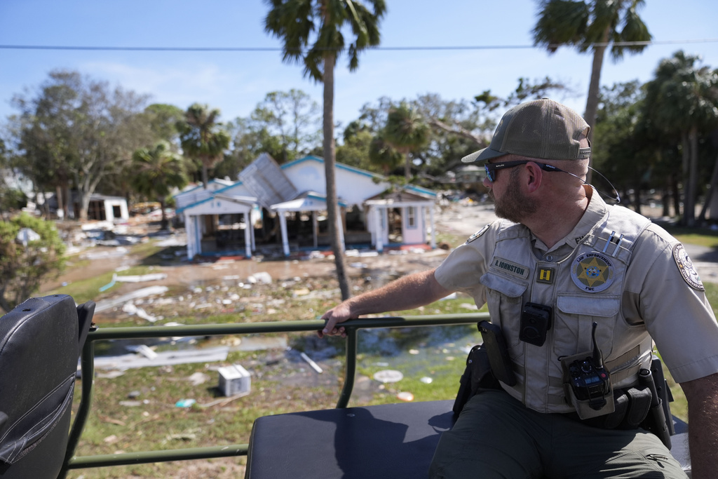 A law enforcement member surveys hurricane damage