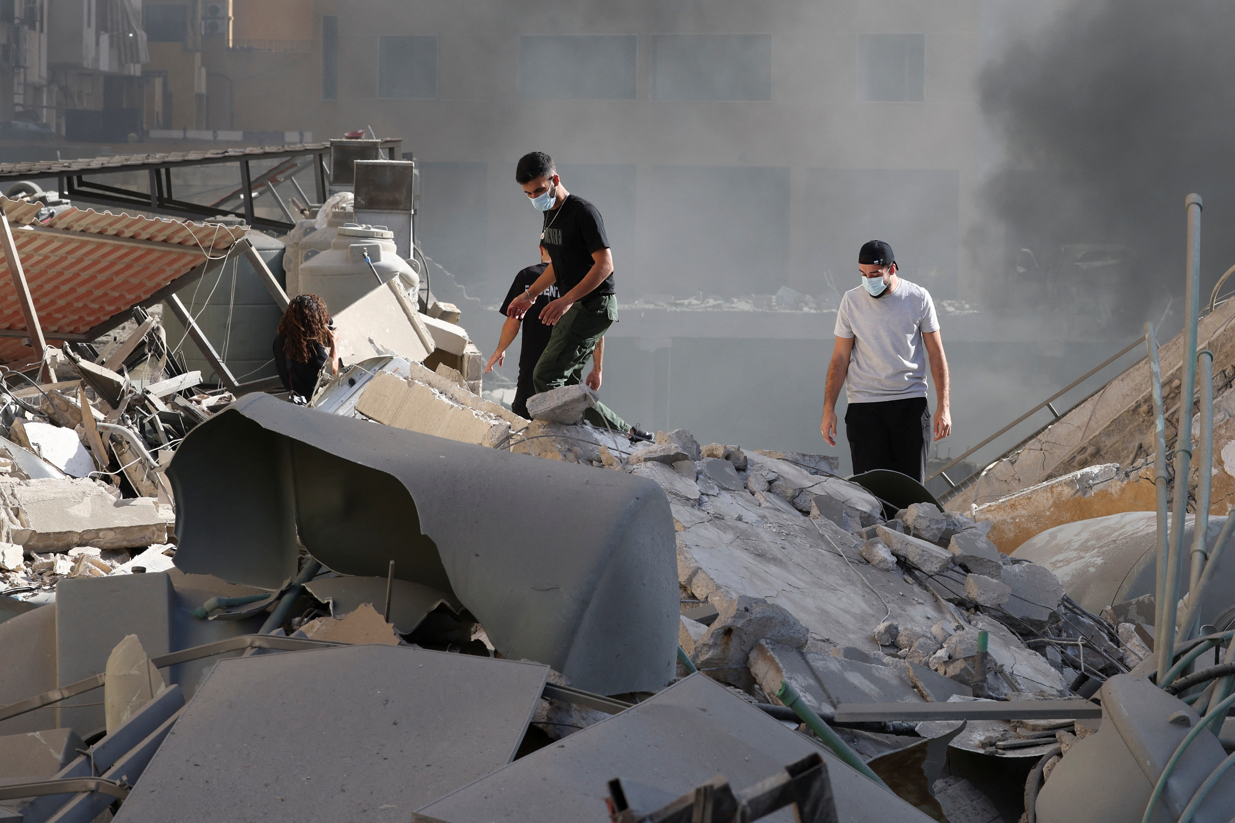 People look at the damage in the aftermath of Israeli strikes in Chiyah, amid the ongoing hostilities between Hezbollah and Israeli forces, Lebanon October 2