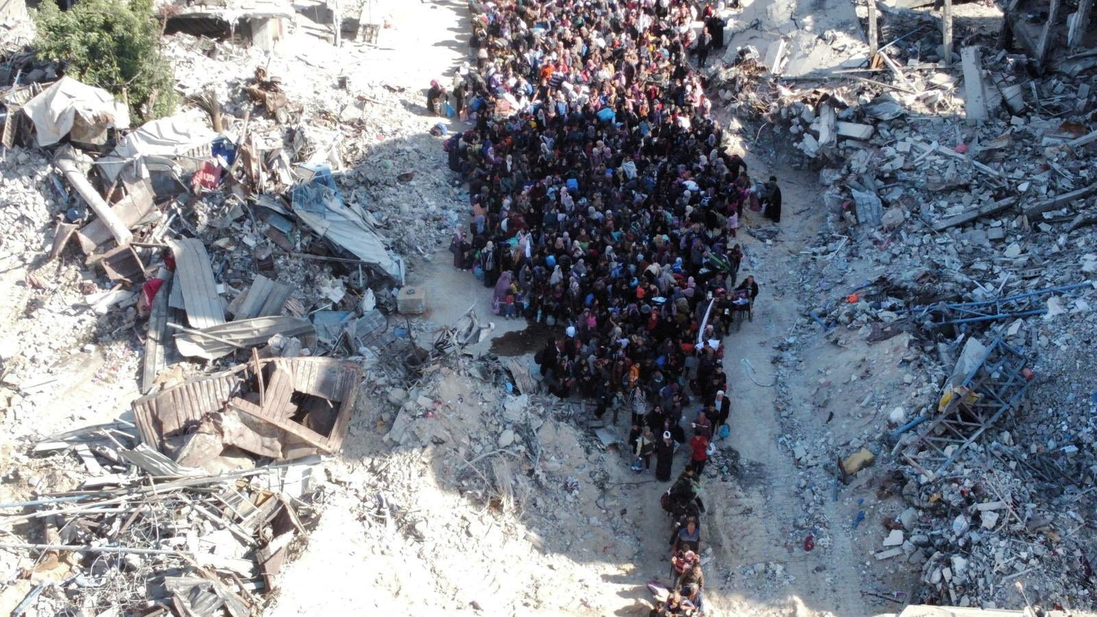 a view of a crowd of people from above between destroyed buildings