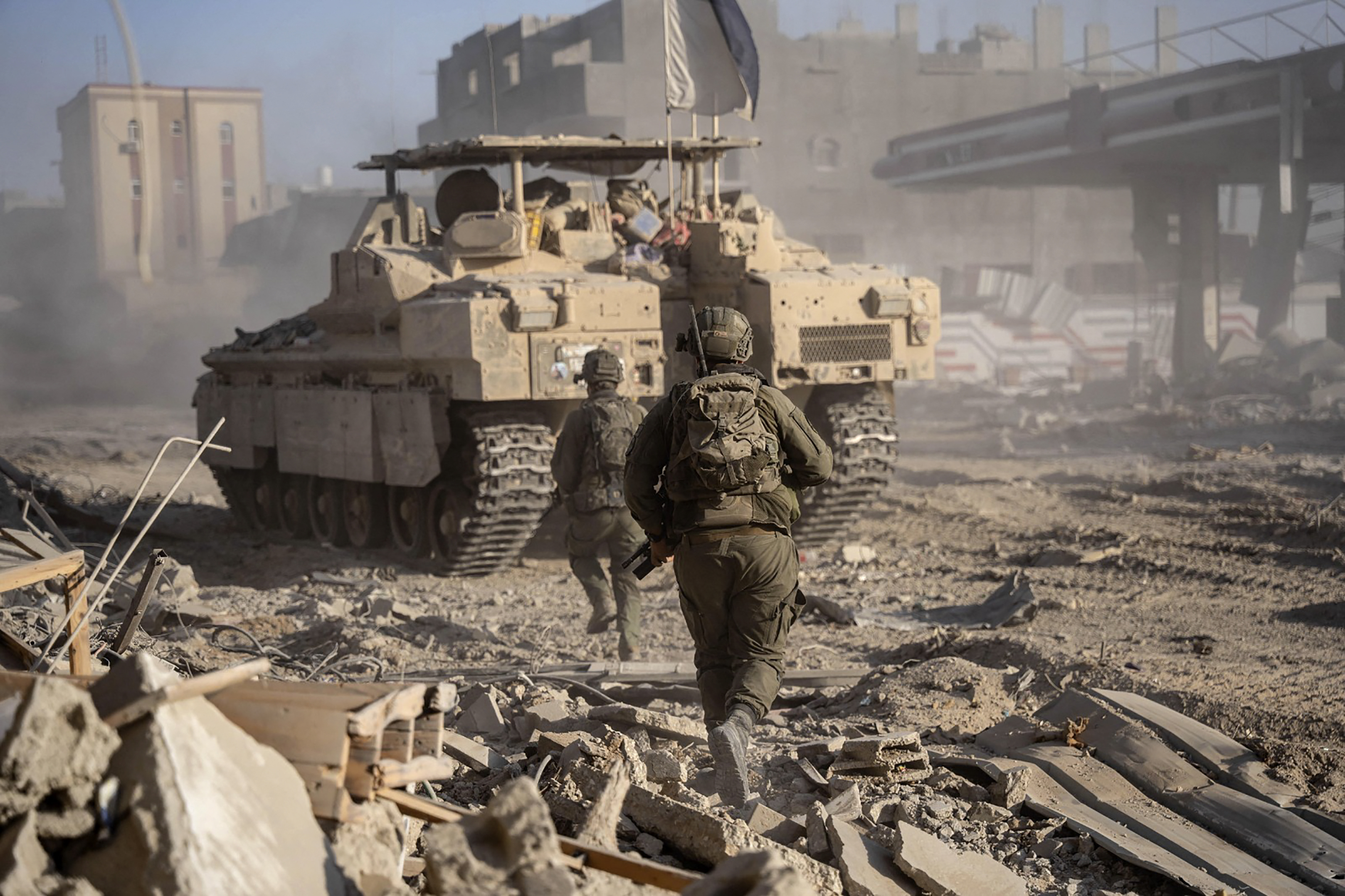 This handout picture released by the Israeli army on July 22, 2024, shows Israeli soldiers behind an armoured vehicle during military operations in the Gaza Strip