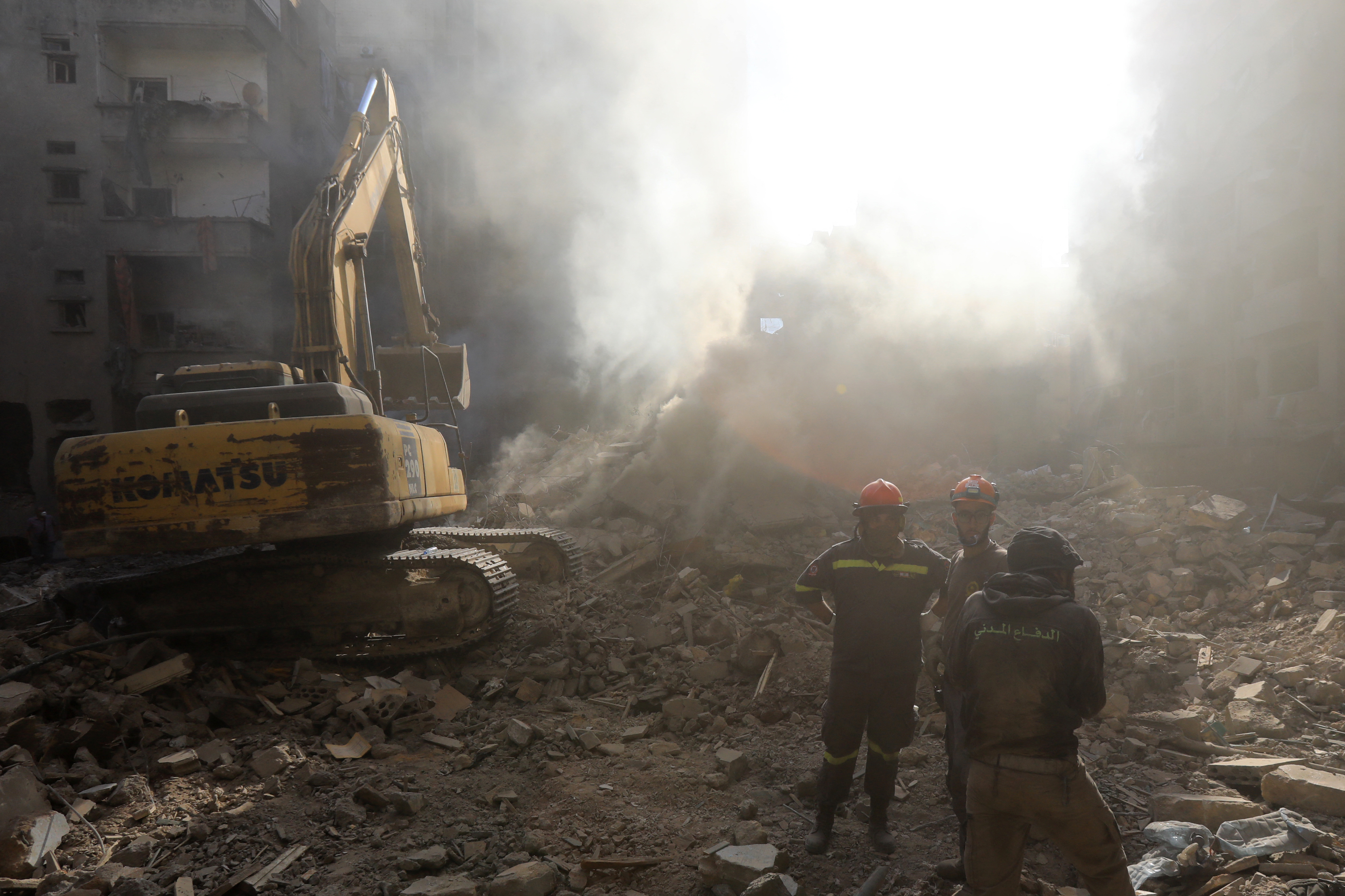 Members of the Lebanese civil defence dig through debris at the site of an Israeli strike on Beirut's Basta neighbourhood on October 11