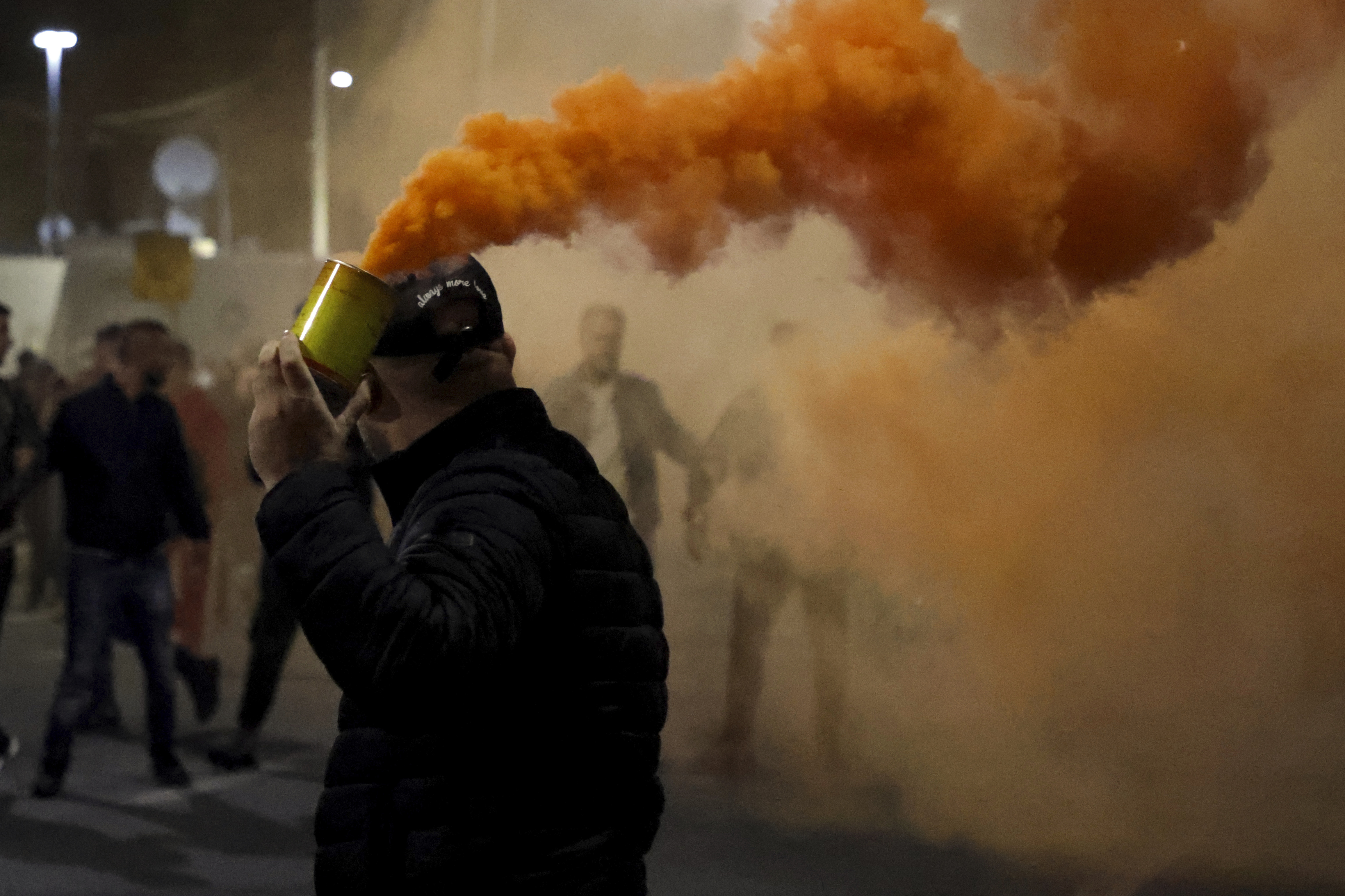An opposition protester holds a flare during an anti-government rally set up by the opposition, in Tirana, Albania, Monday, Oct. 7