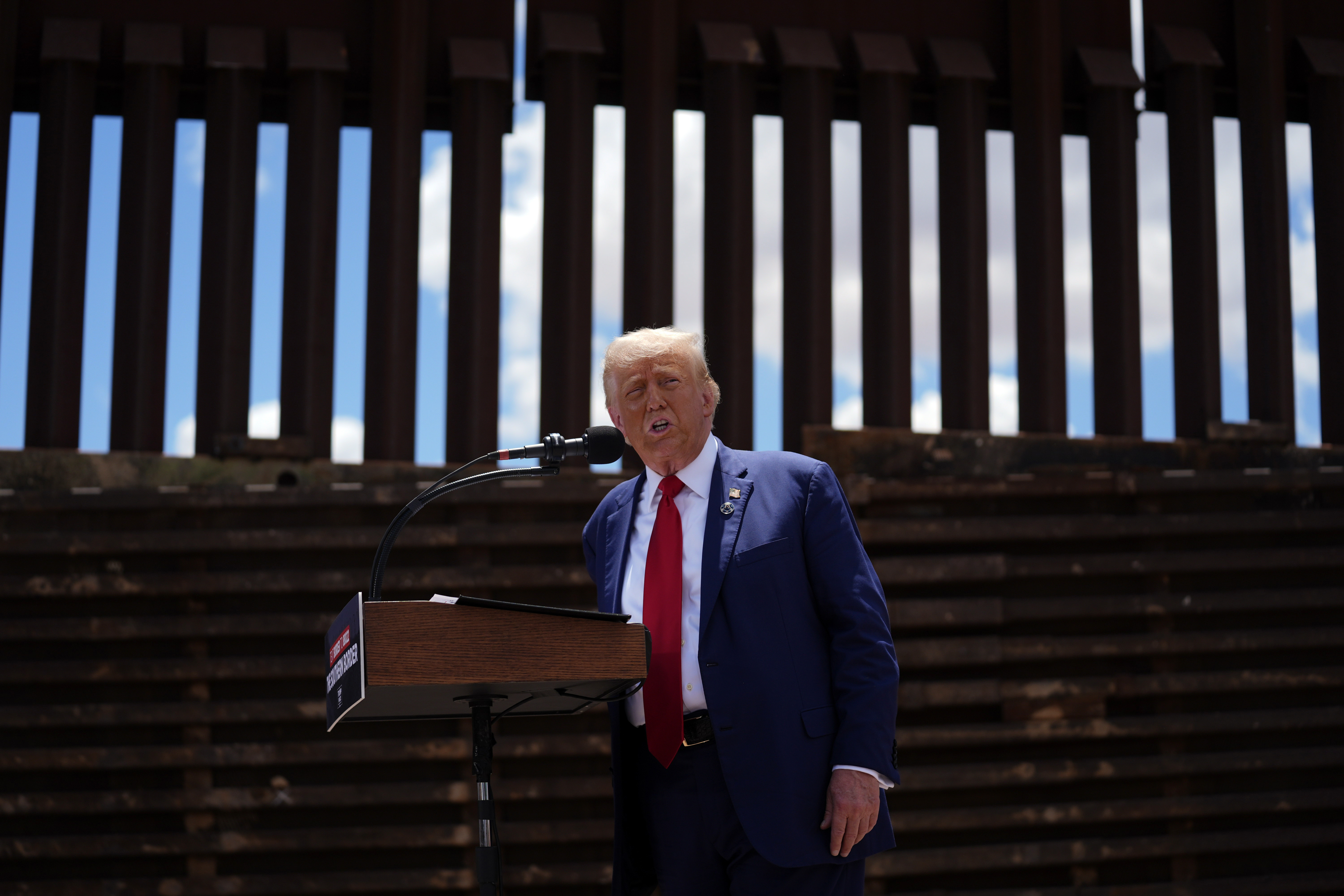 Donald Trump stands in front of the US-Mexico border wall