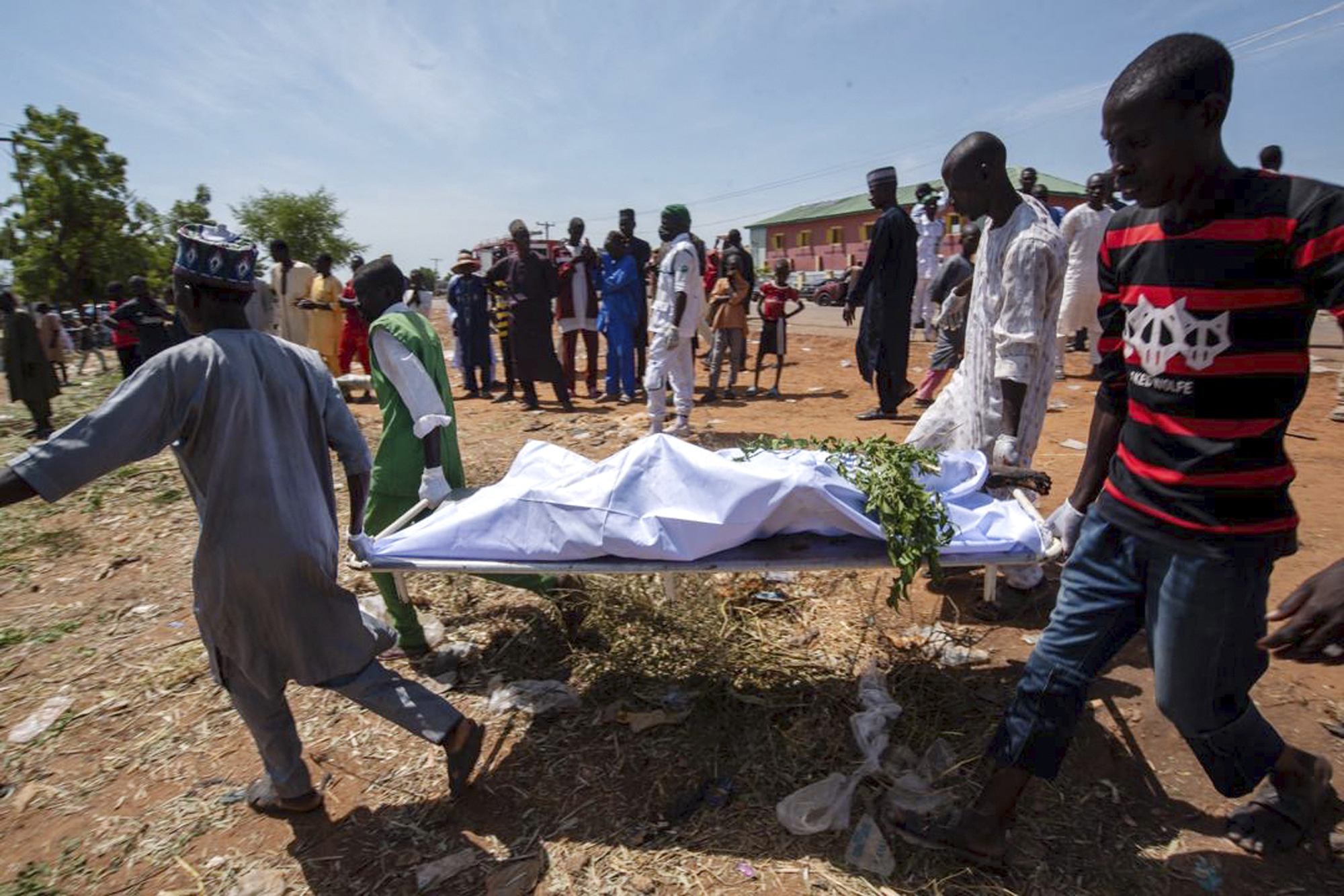 People carry the body of a victim of a tanker explosion in Majia, Nigeria