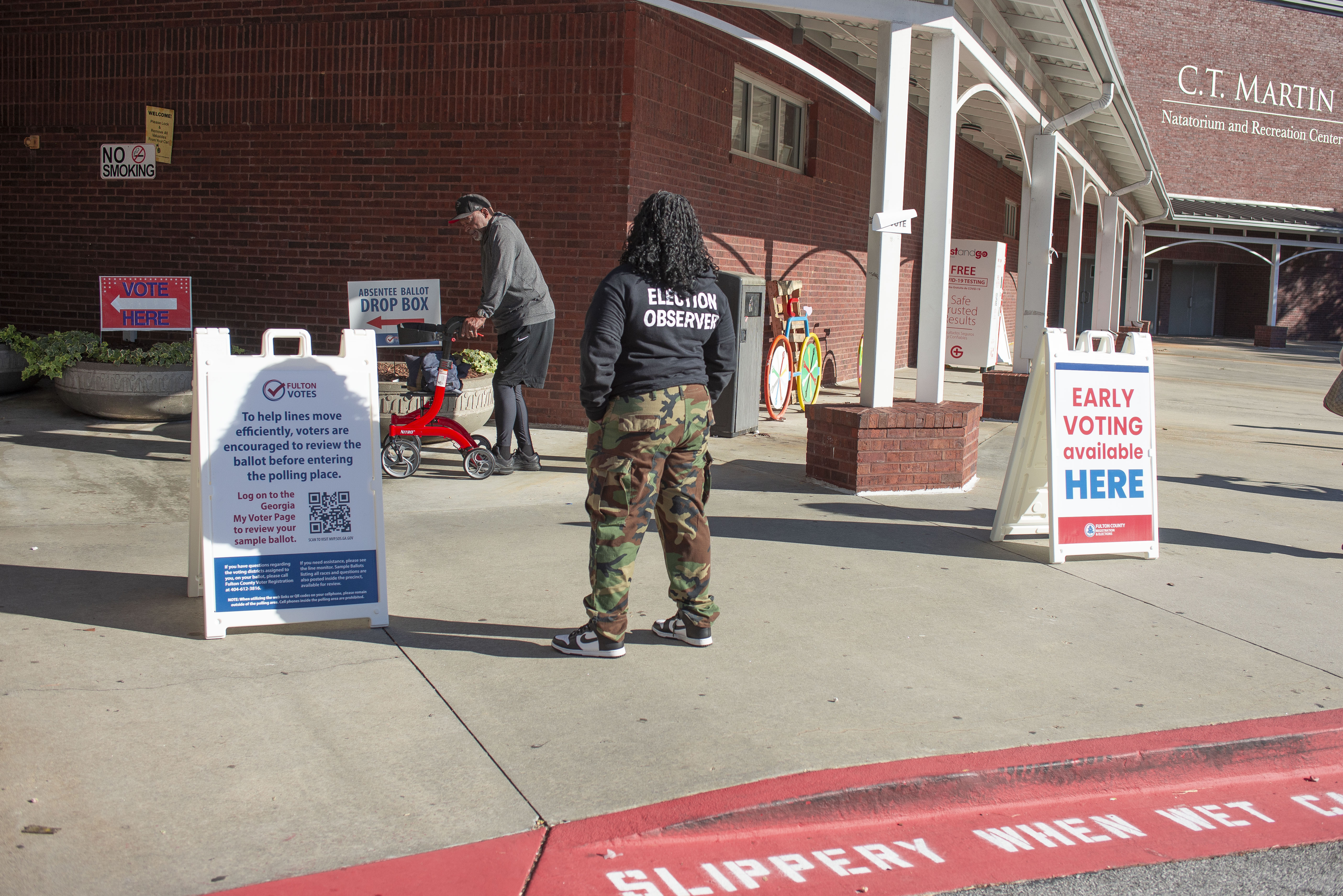 A voting rights election observer stands outside of an early voting site in southwest Atlanta
