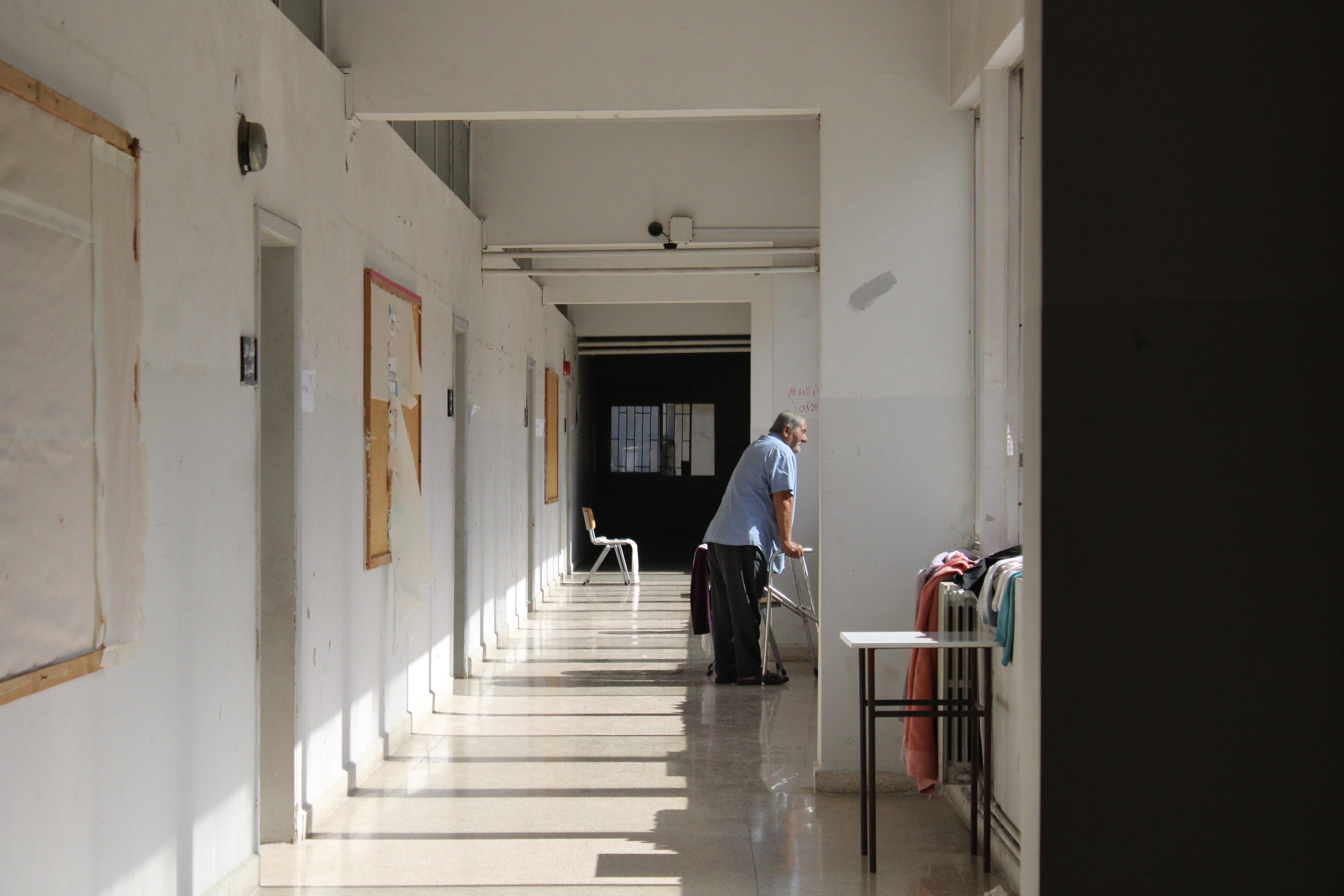 A man looks out of the window from the corridor of Maroun Abboud High School in the Lebanese district of Aley [Agnese Stracquadanio/Al Jazeera]
