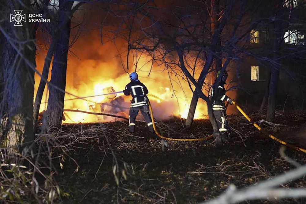 A rescuer from Ukraine's State Emergency Service tries to put out a fire following a Russian strike on a building in Sumy