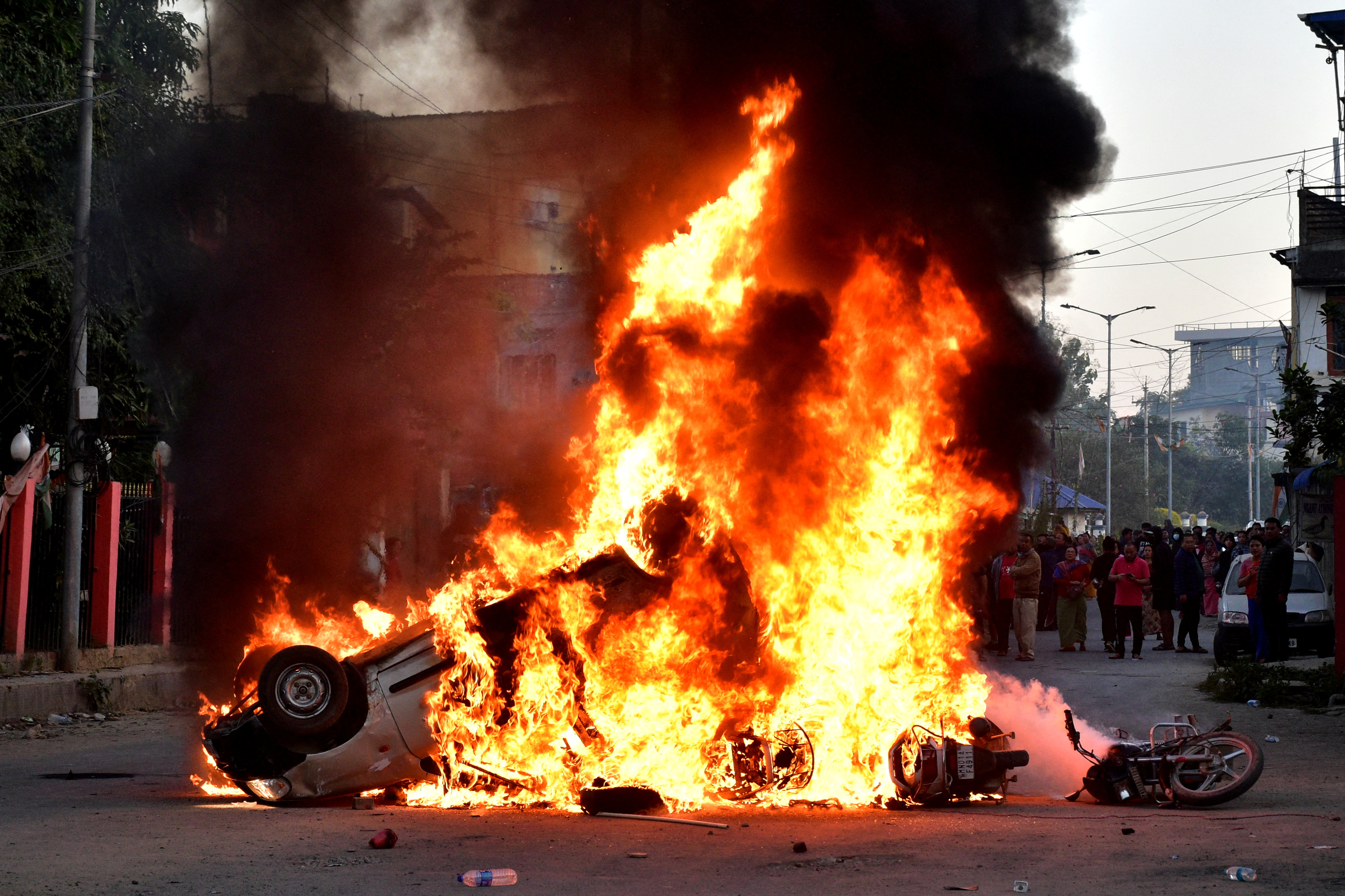 Vehicles burn as demonstrators stand during a protest against the recent killings, in Imphal West, in the northeastern state of Manipur, India, November 16, 2024. REUTERS/Stringer