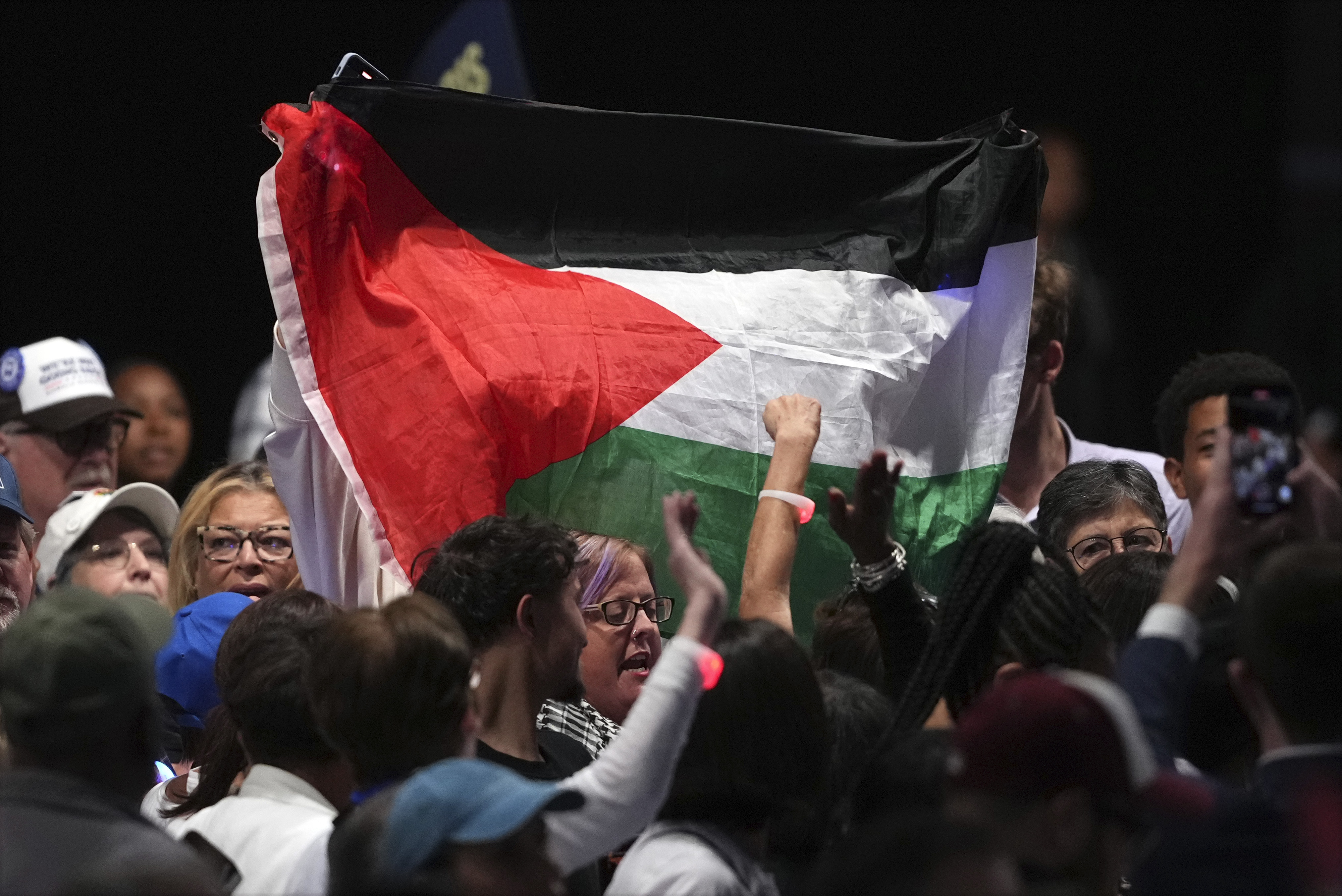 Protesters hold up a Palestinian flag at a Kamala Harris rally