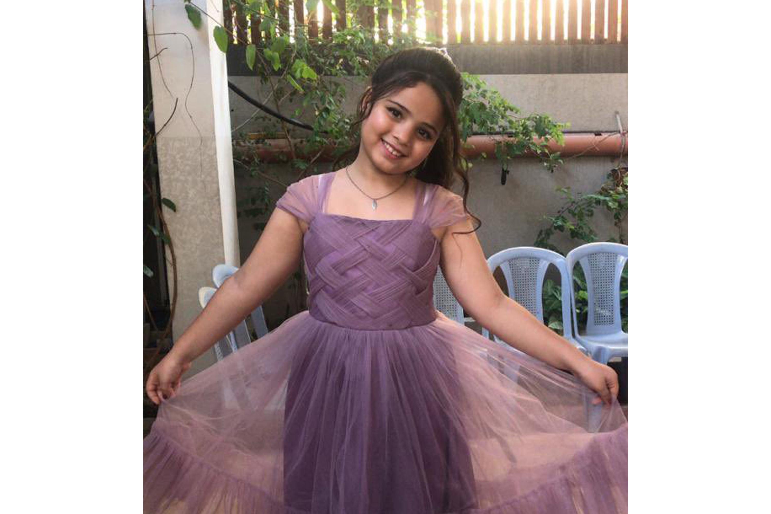a photo of a girl smiling and spreading the lower part of her dress to the sides