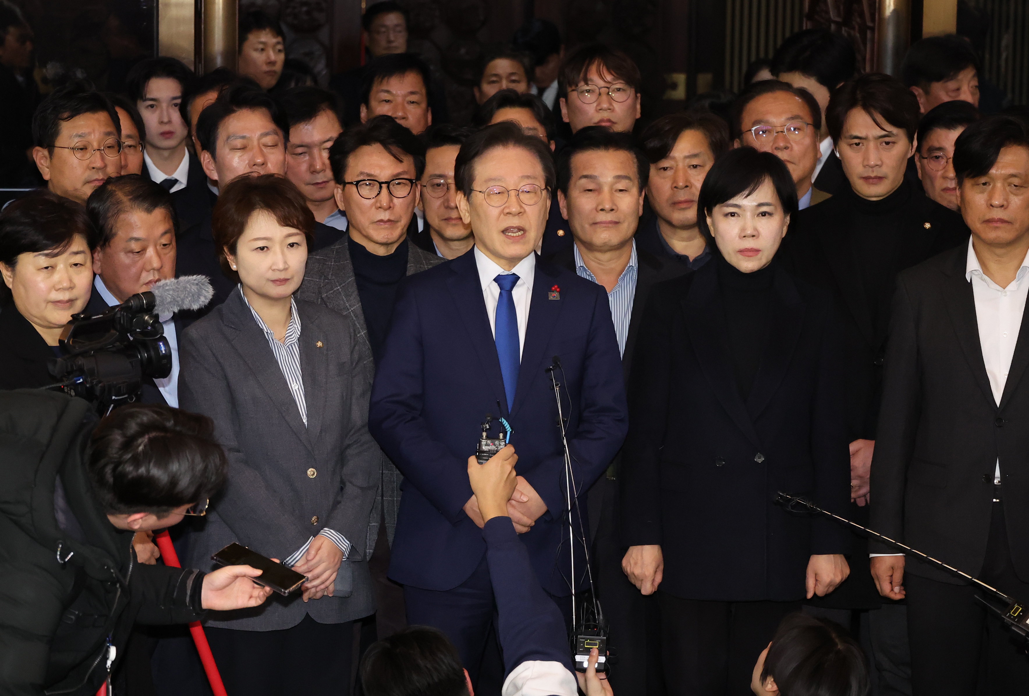 Head of the main opposition Democratic Party Lee Jae-myung (C) announces his stance