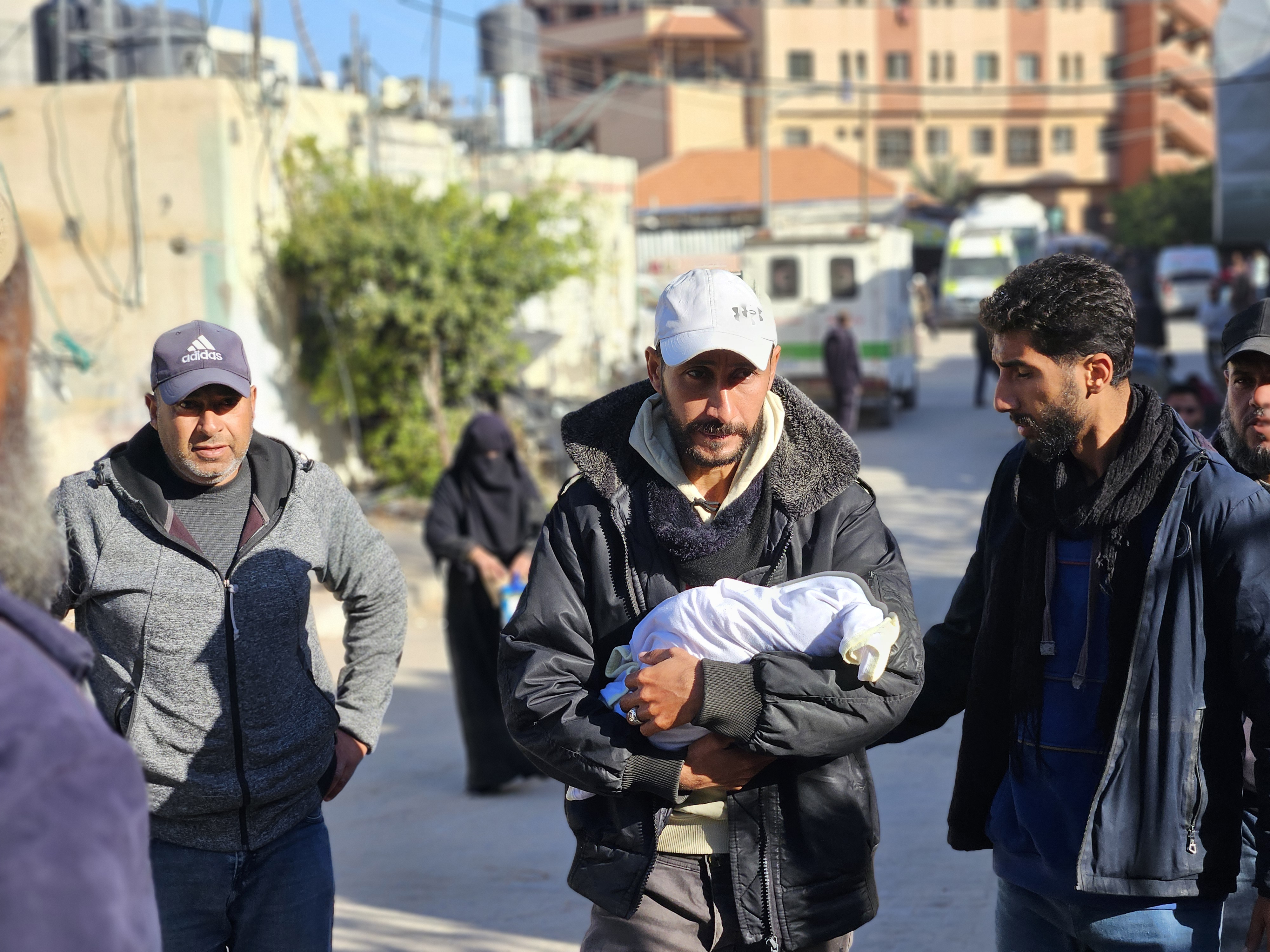 Mahmoud al-Faseeh carries the body of his daughter, three-week-old Sila, who froze to death in the family tent in al-Mawasi