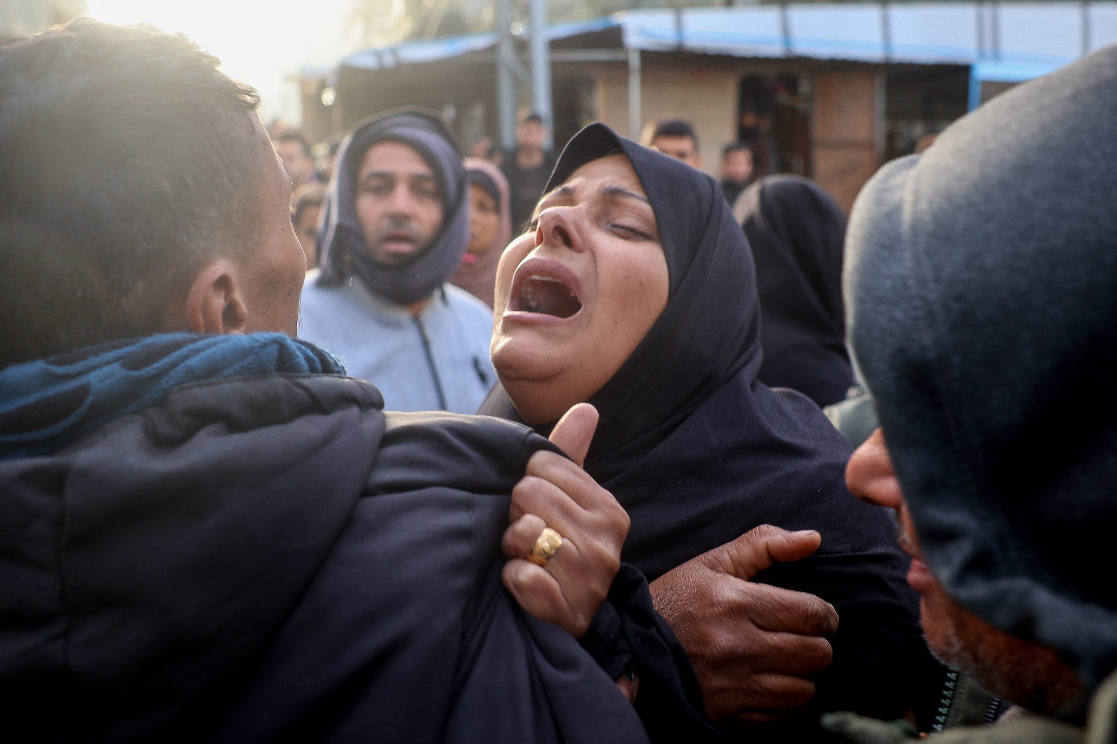 A woman reacts during the funeral of members of the press who were killed in an Israeli strike, at the al-Awda Hospital in the Nuseirat refugee camp in the central Gaza Strip, on December 26