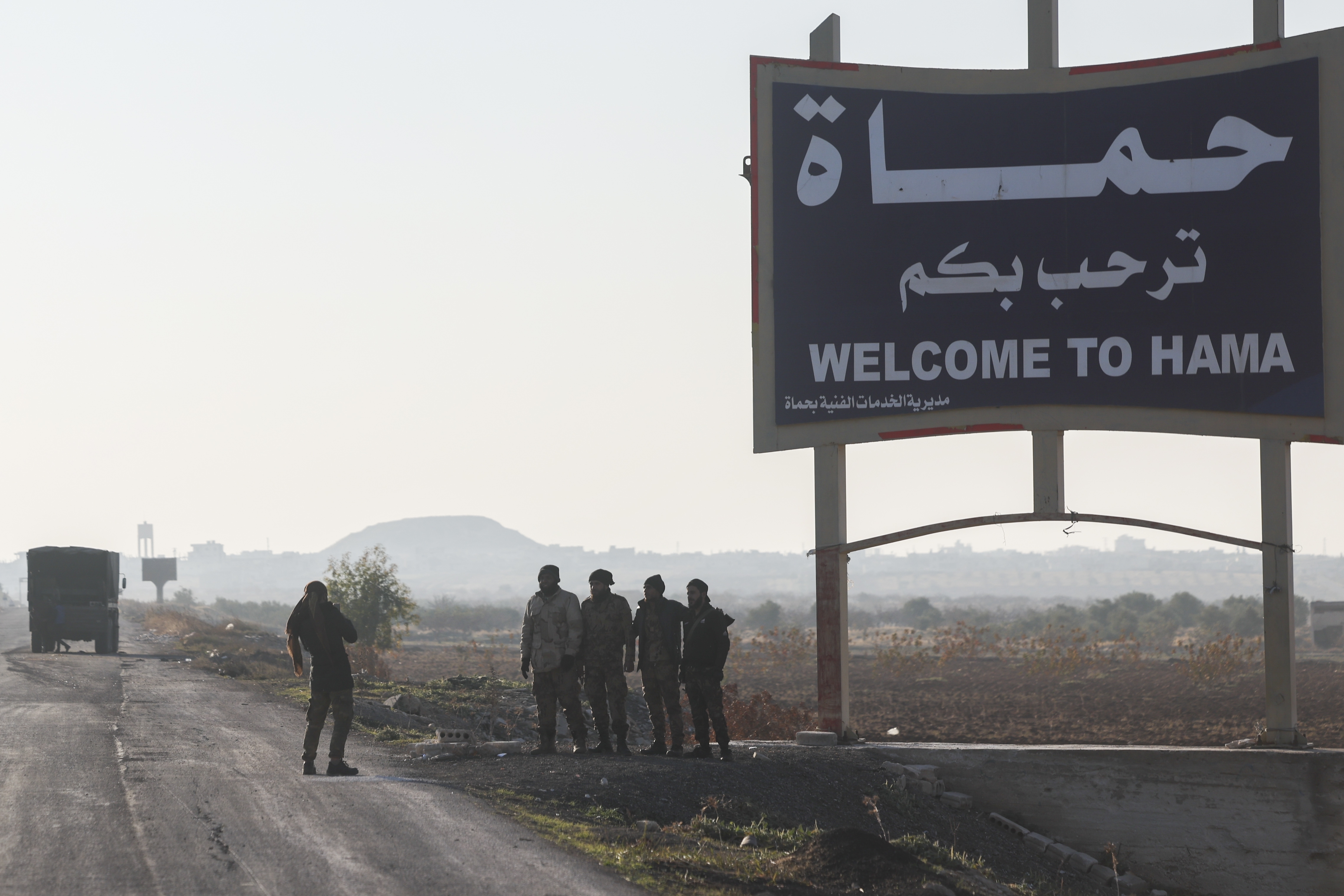 Syrian opposition fighters take pictures in the outskirts of of Hama, Syria