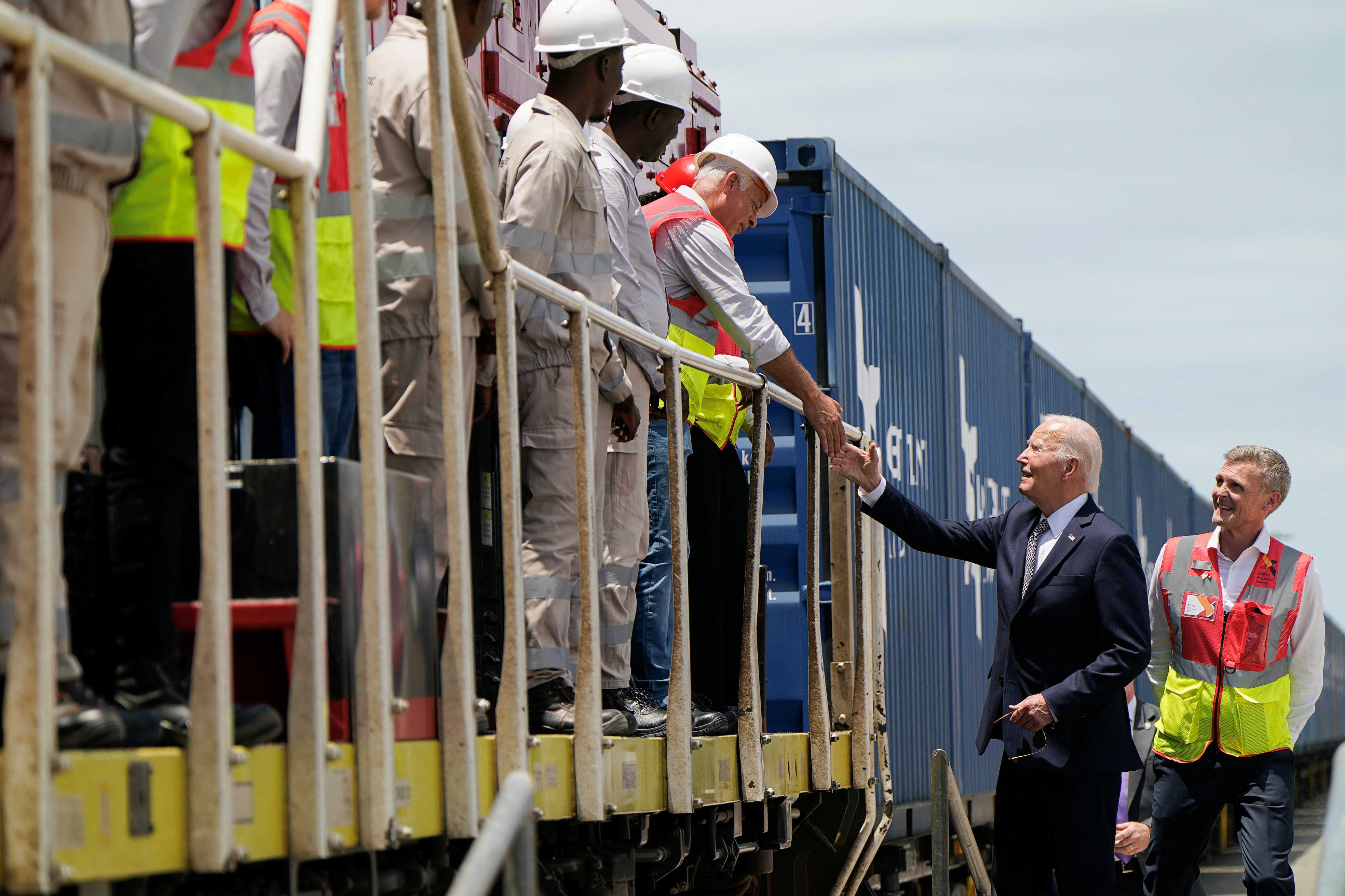 U.S. President Joe Biden goes to shake hands with a man, as he stands with Lobito Atlantic Railway (LAR) Chief Operating Officer Nicolas Gregoir, during a visit to Lobito Port Terminal to receive a briefing on the Lobito Atlantic Railway, in Lobito, Angola, December 4, 2024. [REUTERS/Elizabeth Frantz]