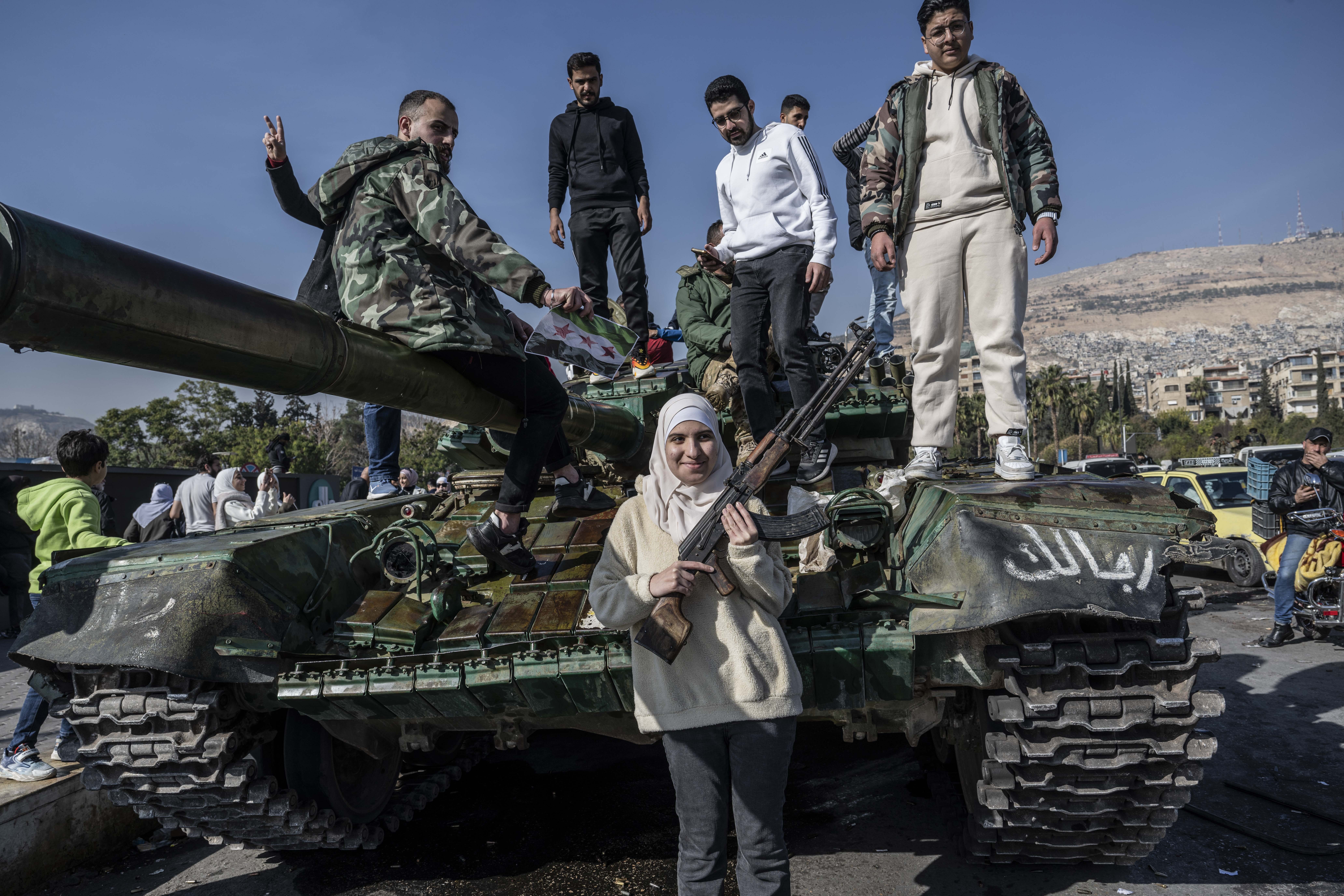 People celebrate the collapse of 61 years of Baath Party rule as they gather at Umayyad Square after armed groups take control in Damascus, Syria