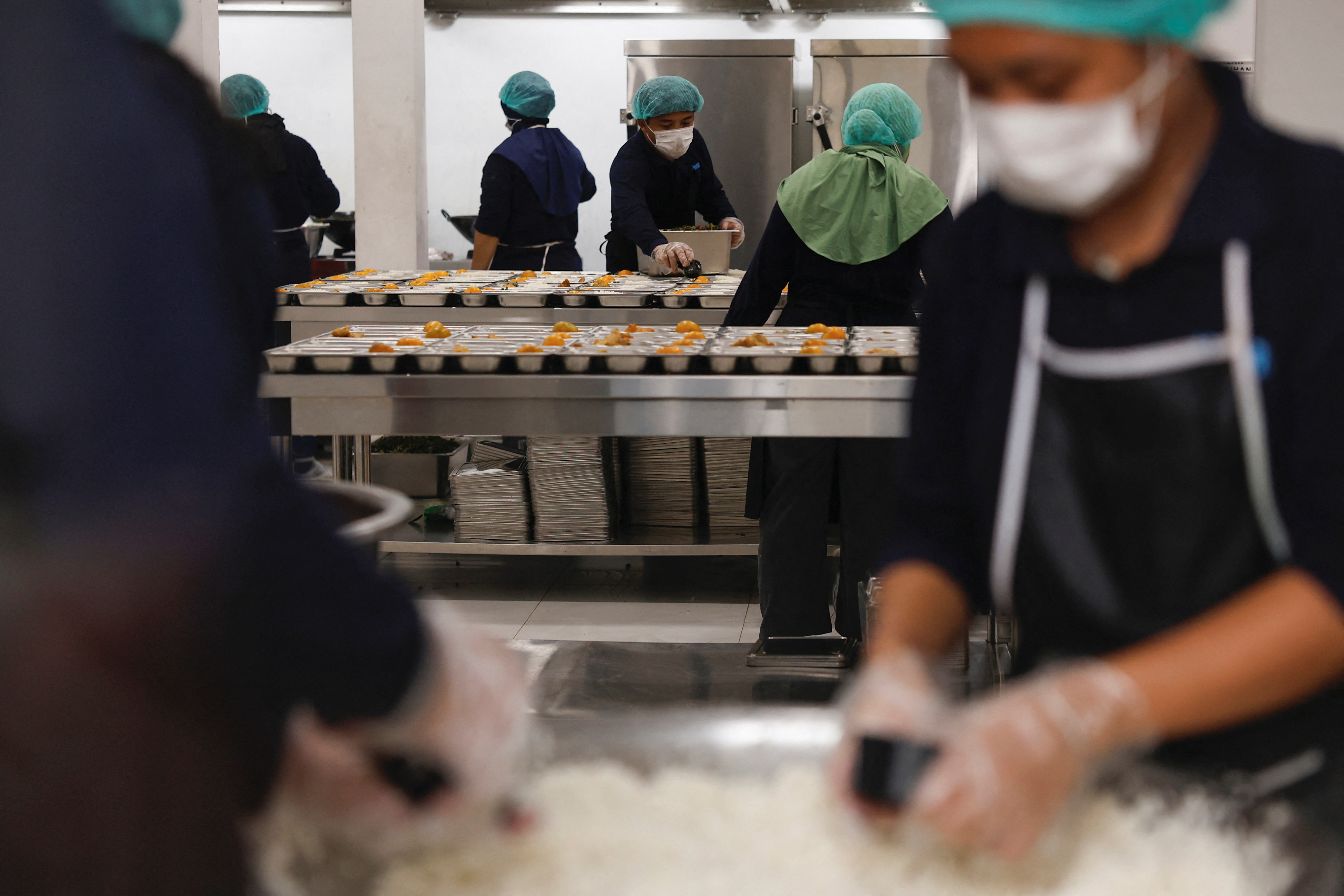 Staff members prepare meals to be distributed free for children and pregnant women, at a kitchen in Jakarta, Indonesia, January 6