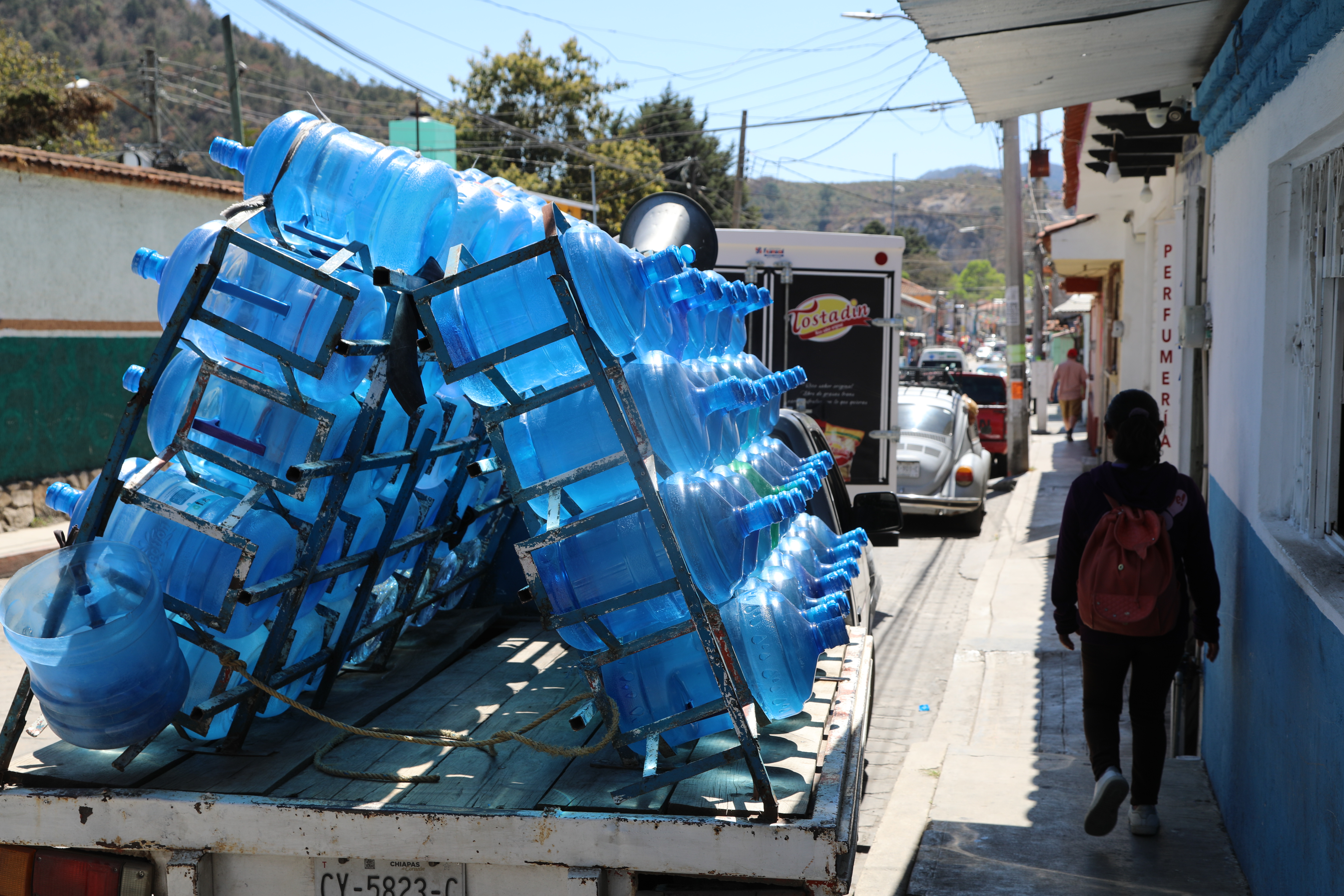A van makes deliveries of water jugs in San Cristobal
