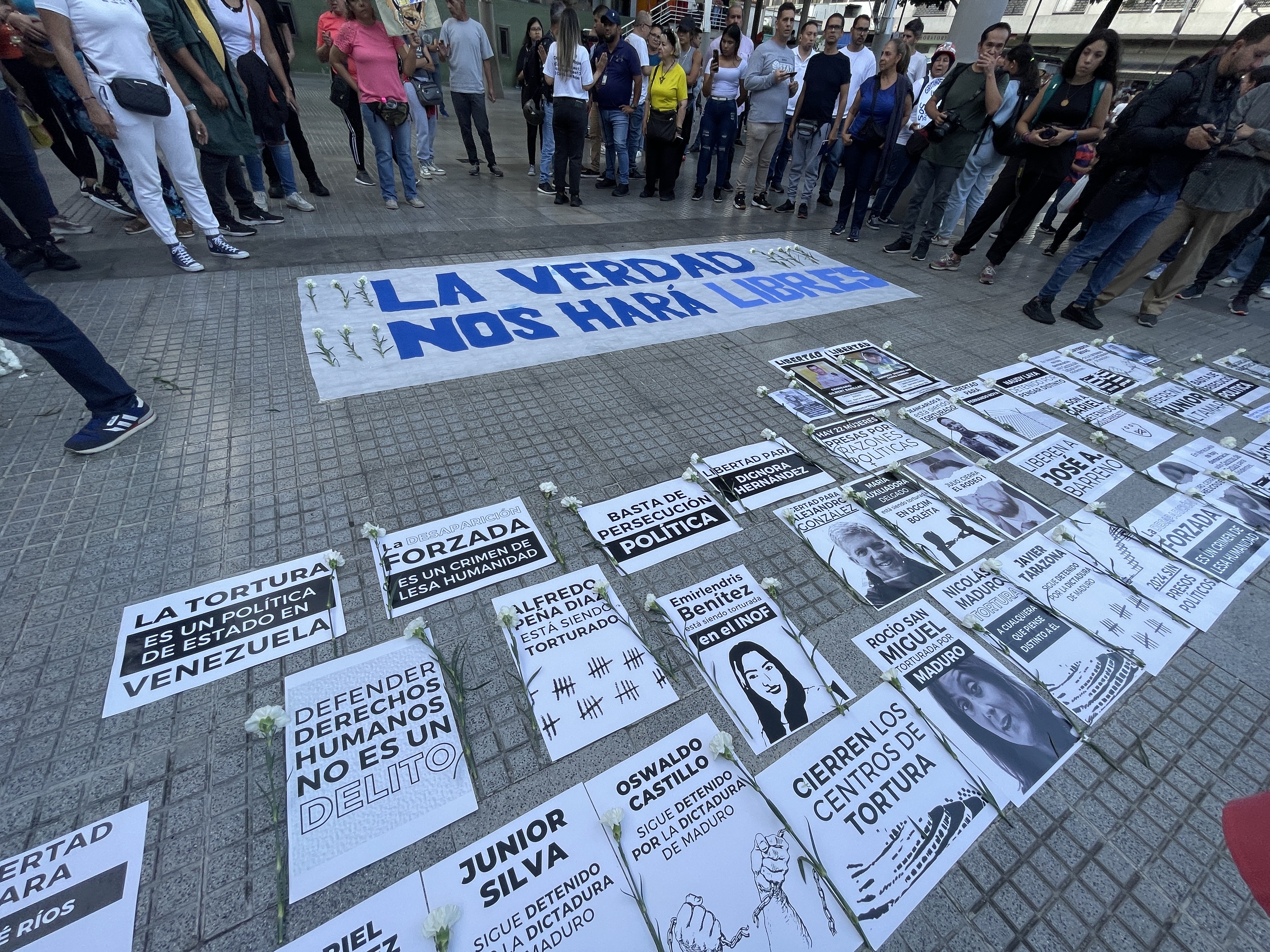 A vigil for political prisoners in Caracas, with posters spread on the ground.