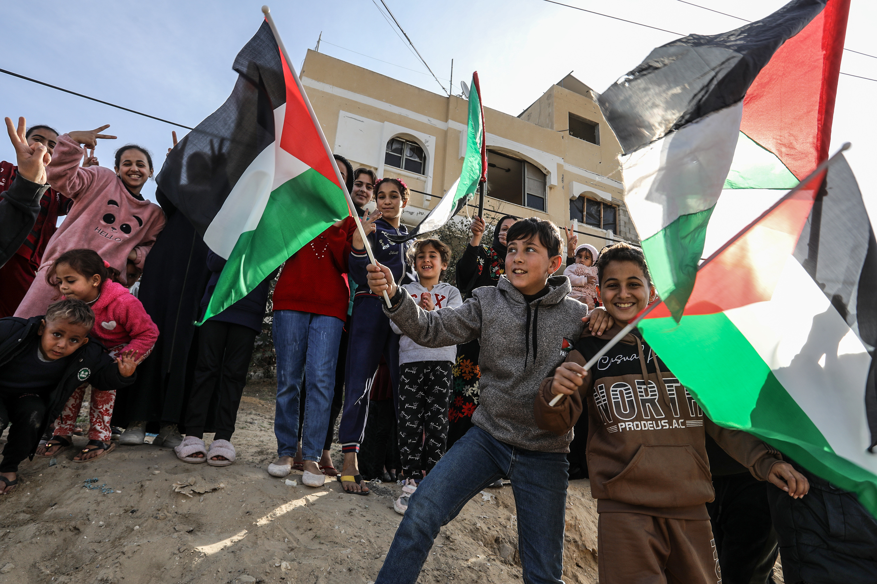 RAFAH, GAZA - JANUARY 19: Children are waving Palestinian flags as Palestinians returning to Rafah city demonstrate their joy after the announcement of ceasefire and hostage-prisoner swap deal between Hamas and Israel on January 19, 2025