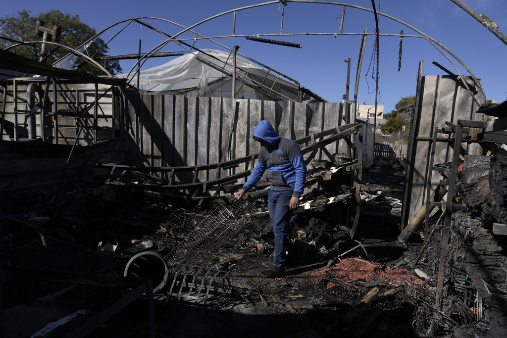 a child walks past burnt remains of a building