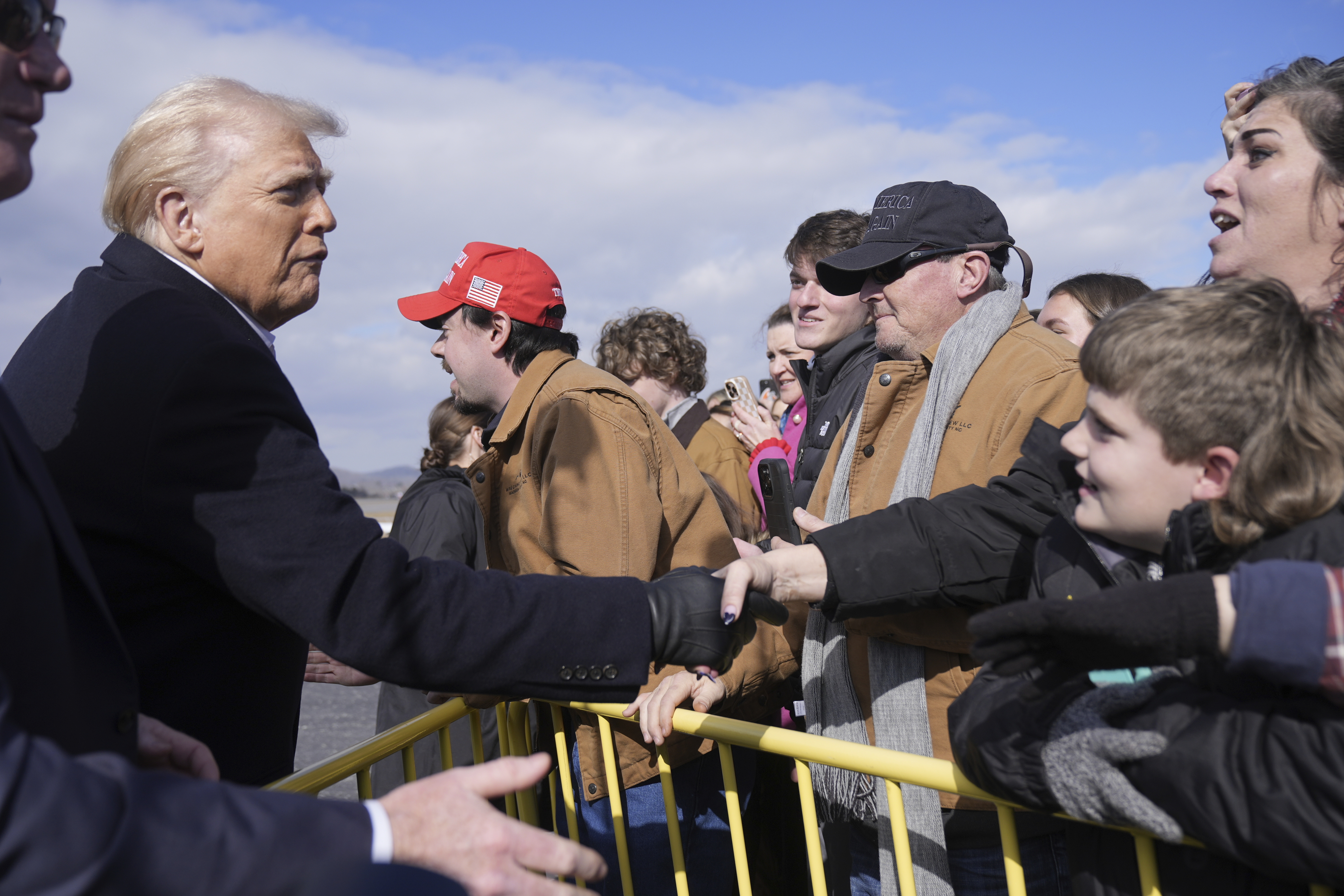 Donald Trump shakes hands with supporters at the airport in Asheville