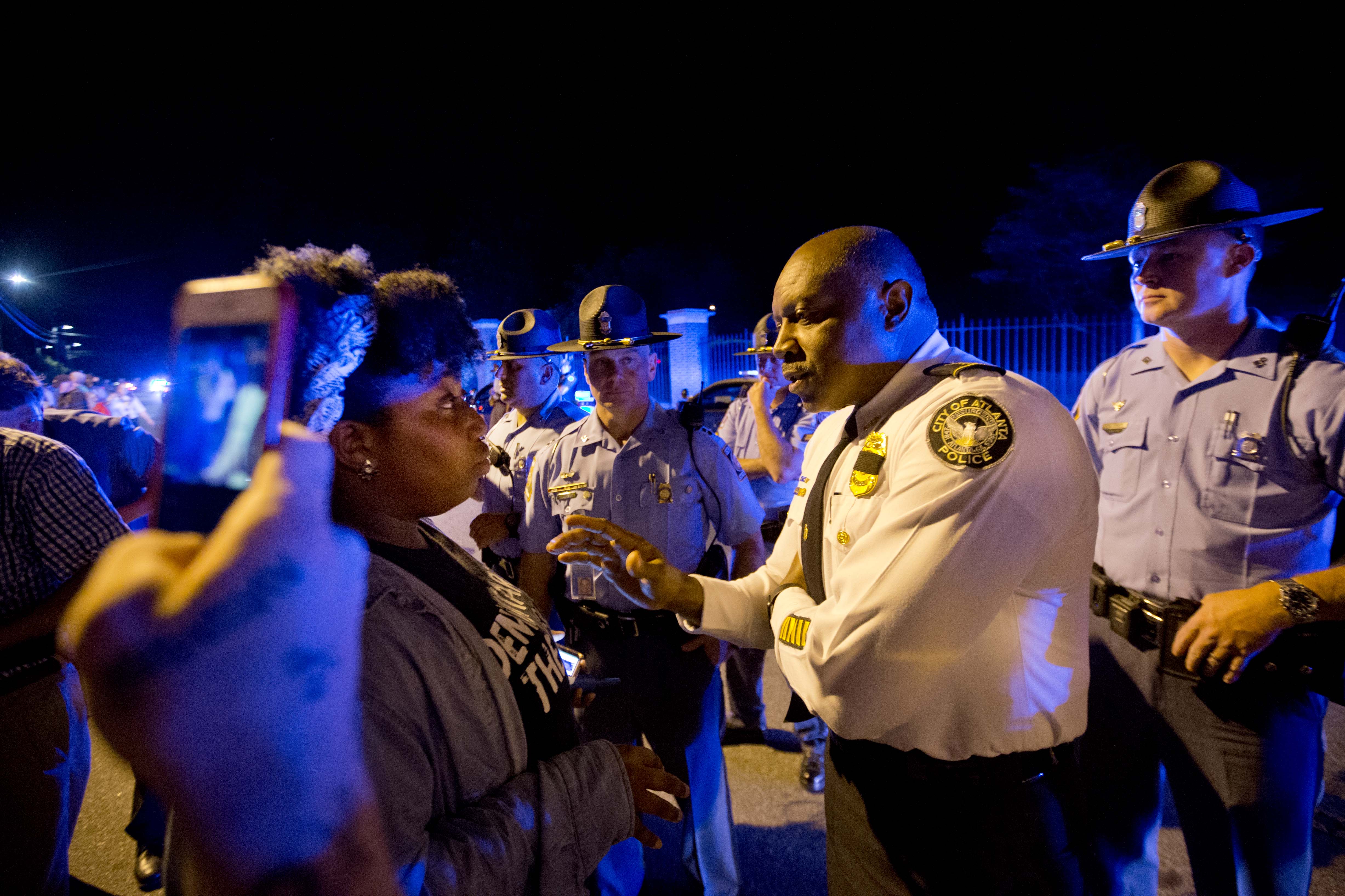 Aurielle Marie speaks to police chief George Turner outdoors at night in Atlanta