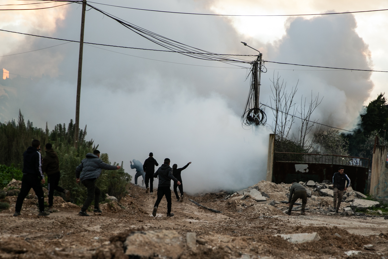 Tear gas in the air with Palestinians in the distance