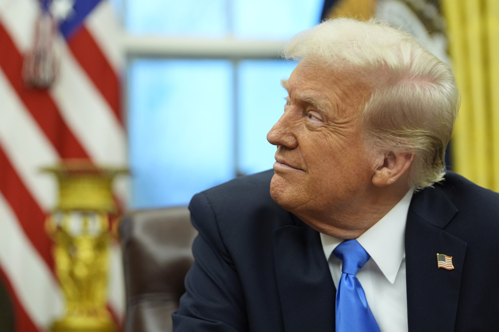 President Donald Trump listens as Elon Musk speaks in the Oval Office at the White House.
