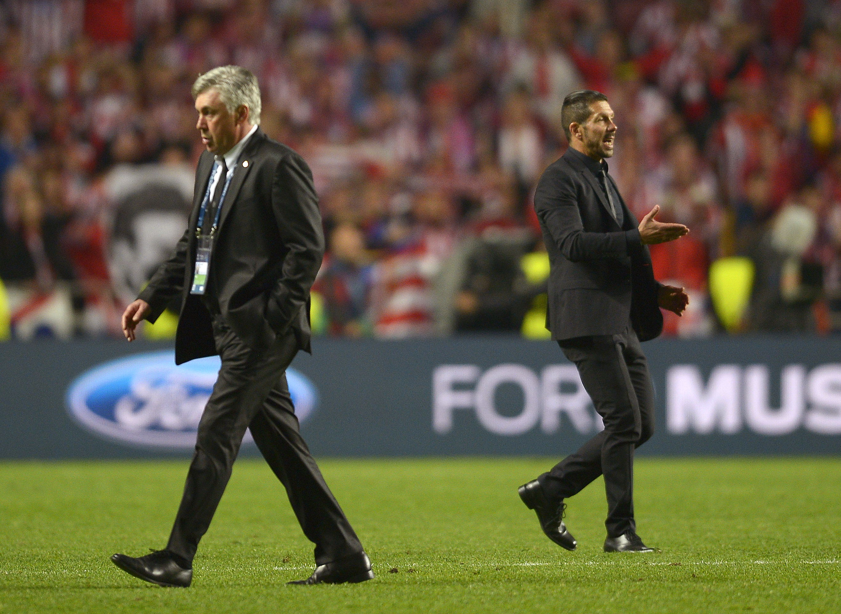 Atletico's coach Diego Simeone, left, walks by Real's coach Carlo Ancelotti, right, during the Champions League final soccer match between Atletico Madrid and Real Madrid, at the Luz stadium, in Lisbon, Portugal, Saturday, May 24, 2014. (AP Photo/Manu Fernandez)