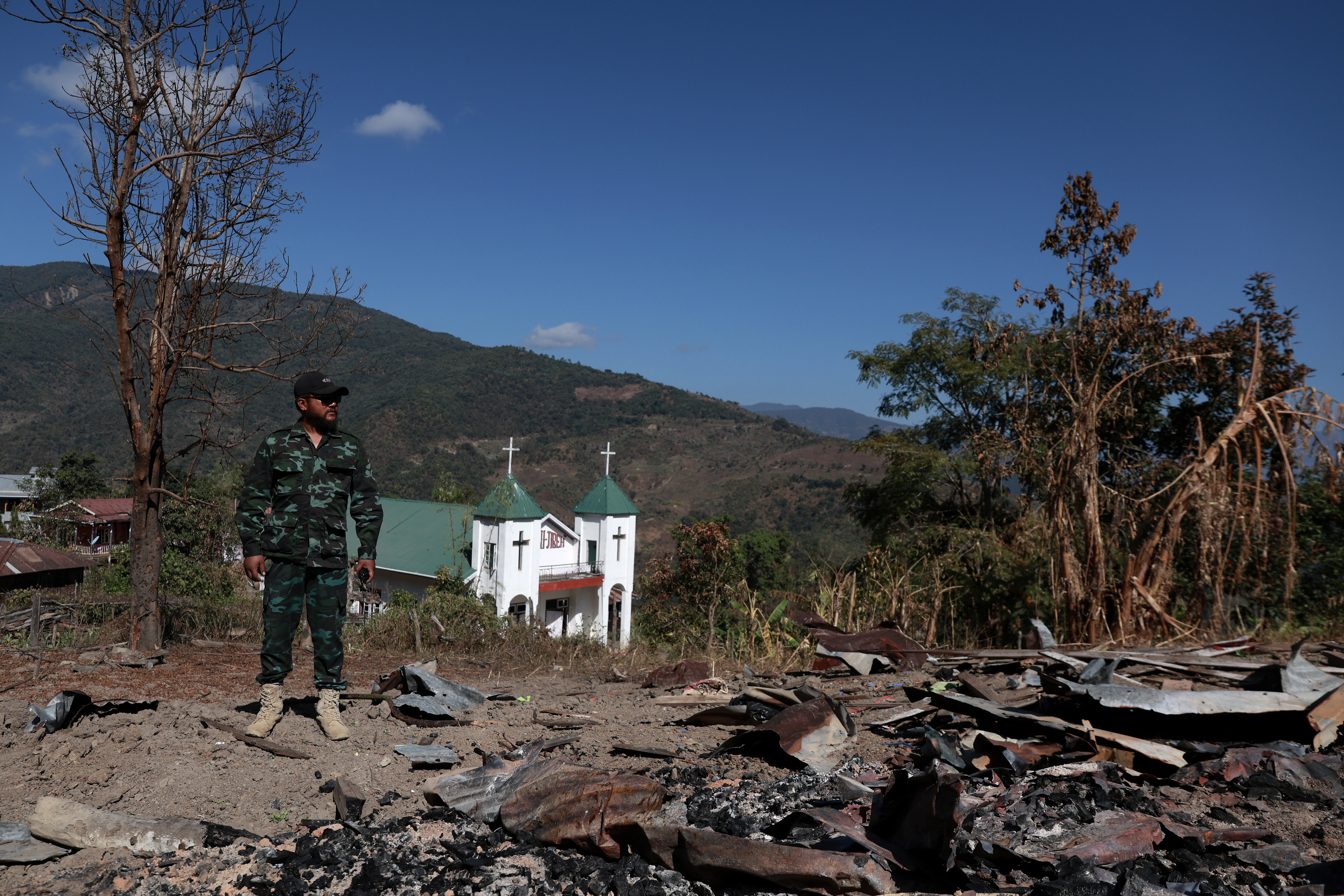 A Chin National Defence Force (CNDF) fighter stands on the ruins of a church bombed by a Myanmar military jet in Falam township, Chin State, Myanmar, December 31, 2024. Valeria Mongelli/Al Jazeera