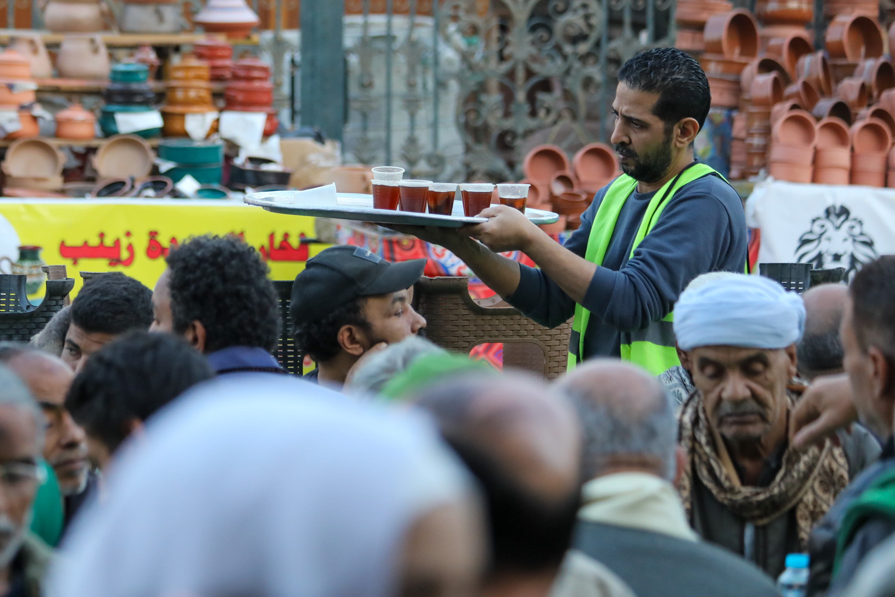 A volunteer carries a tray of drinks