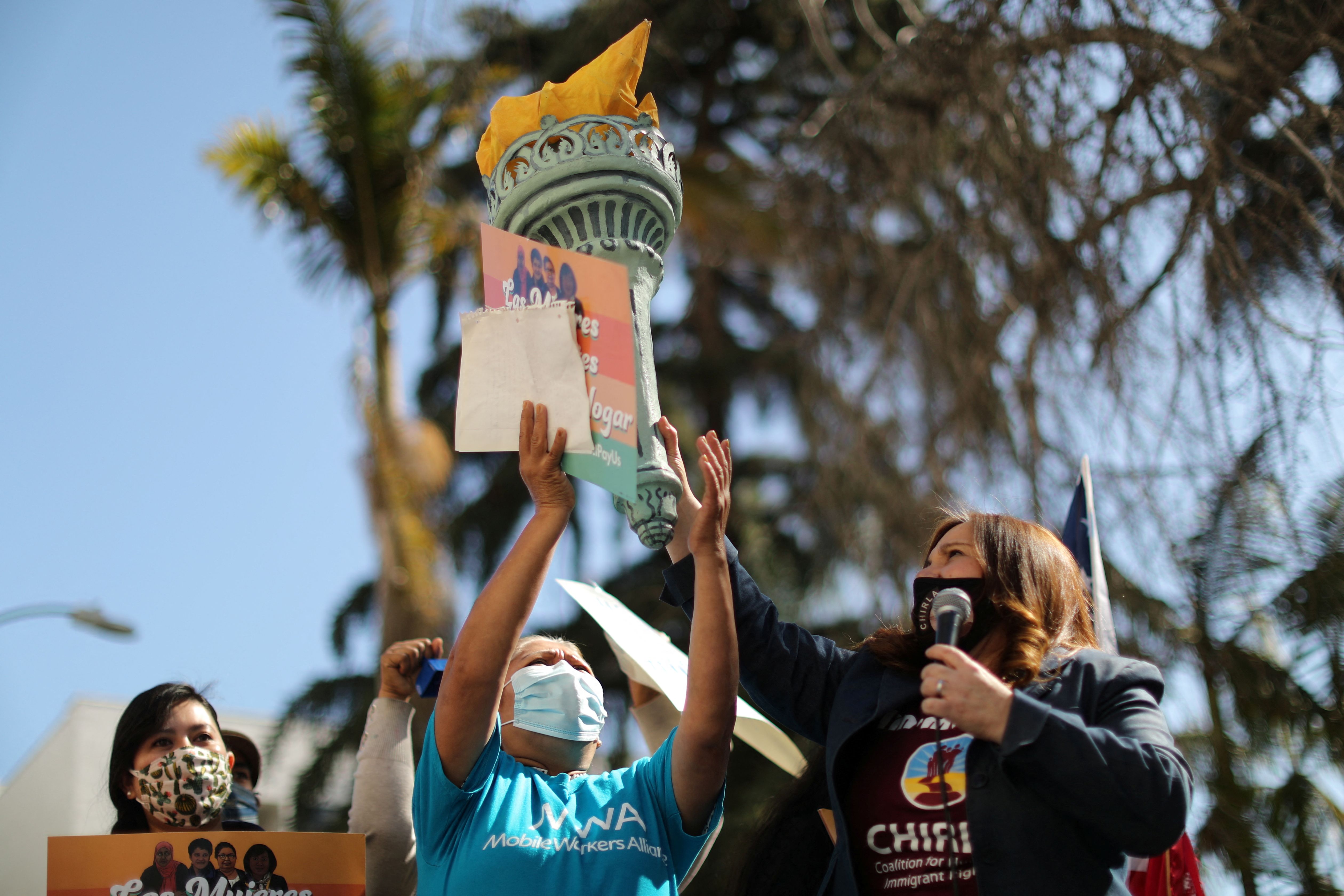 A person holds up a model of the Statue of Liberty's torch