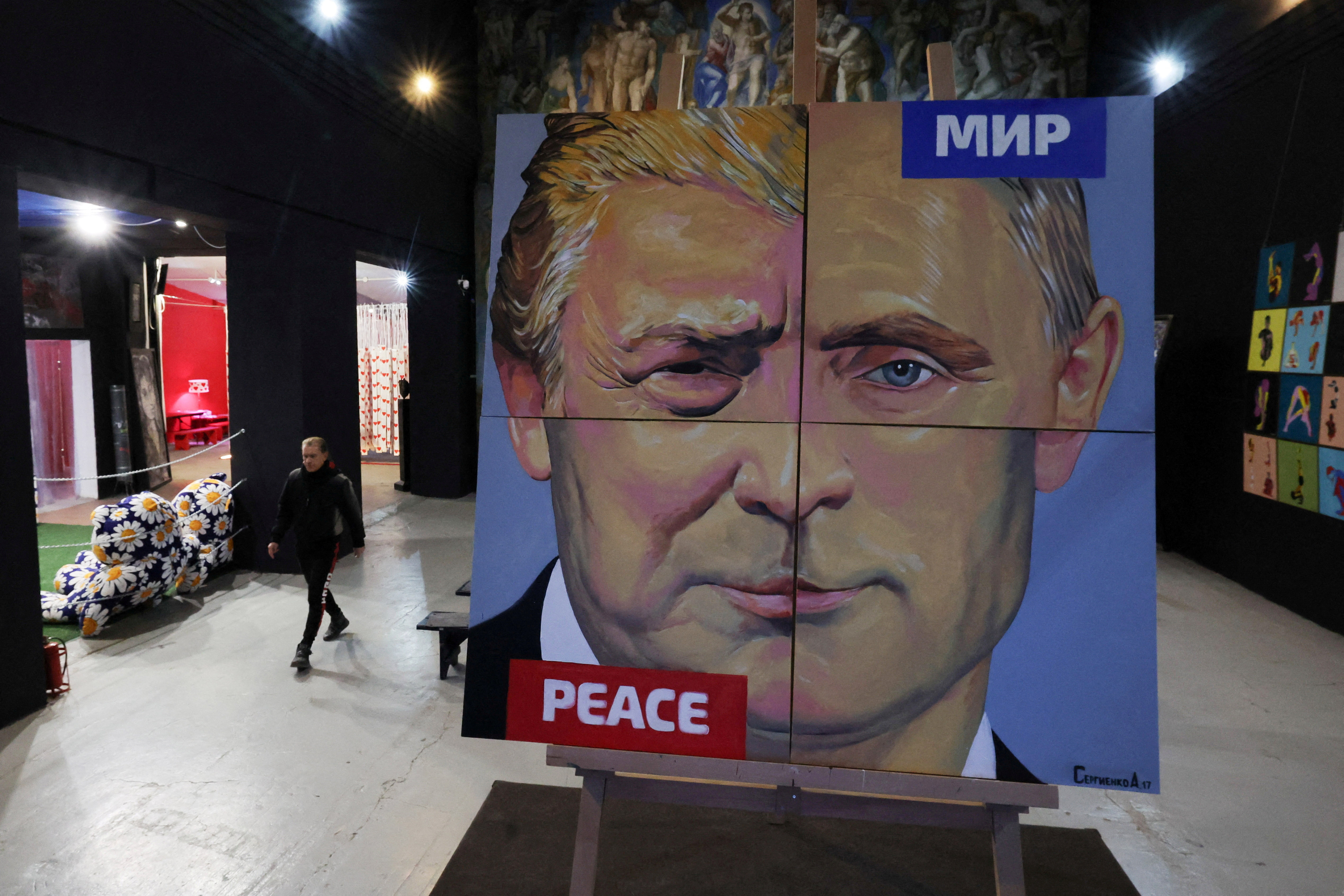 FILE PHOTO: Artist Alexei Sergienko walks towards his painting ?Peace to the world" showing a combination of faces of Russian President Vladimir Putin and U.S. President Donald Trump, at the Sergienko gallery in Saint Petersburg, Russia March 17, 2025. REUTERS/Anton Vaganov NO RESALES. NO ARCHIVES/File Photo