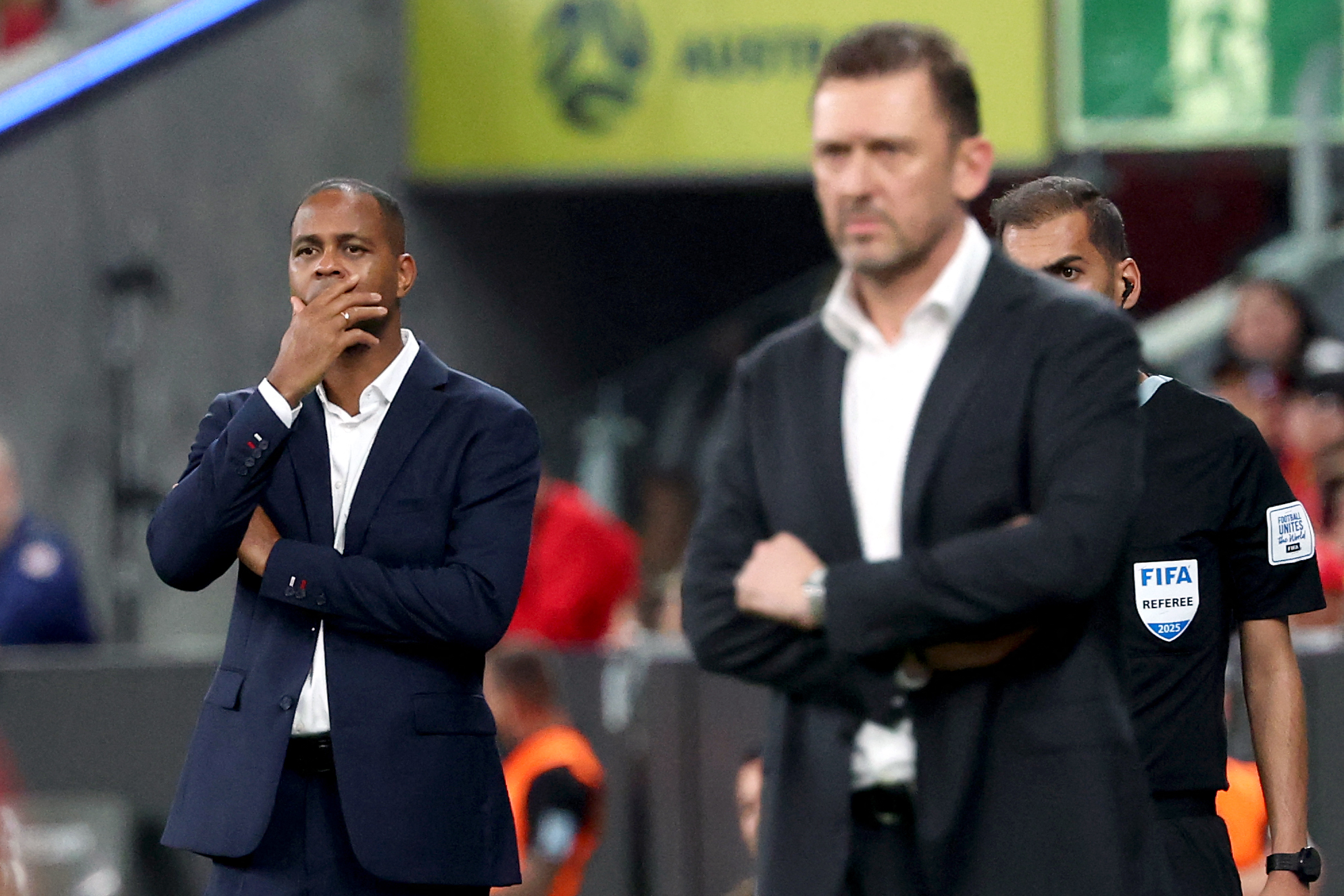 Indonesias head coach Patrick Kluivert (L) reacts as he watches the game with Australias head coach Tony Popovic during the 2026 FIFA World Cup Asian qualification football match between Indonesia and Australia at Allianz Stadium in Sydney on March 20, 2025. (Photo by DAVID GRAY / AFP) / -- IMAGE RESTRICTED TO EDITORIAL USE - STRICTLY NO COMMERCIAL USE --