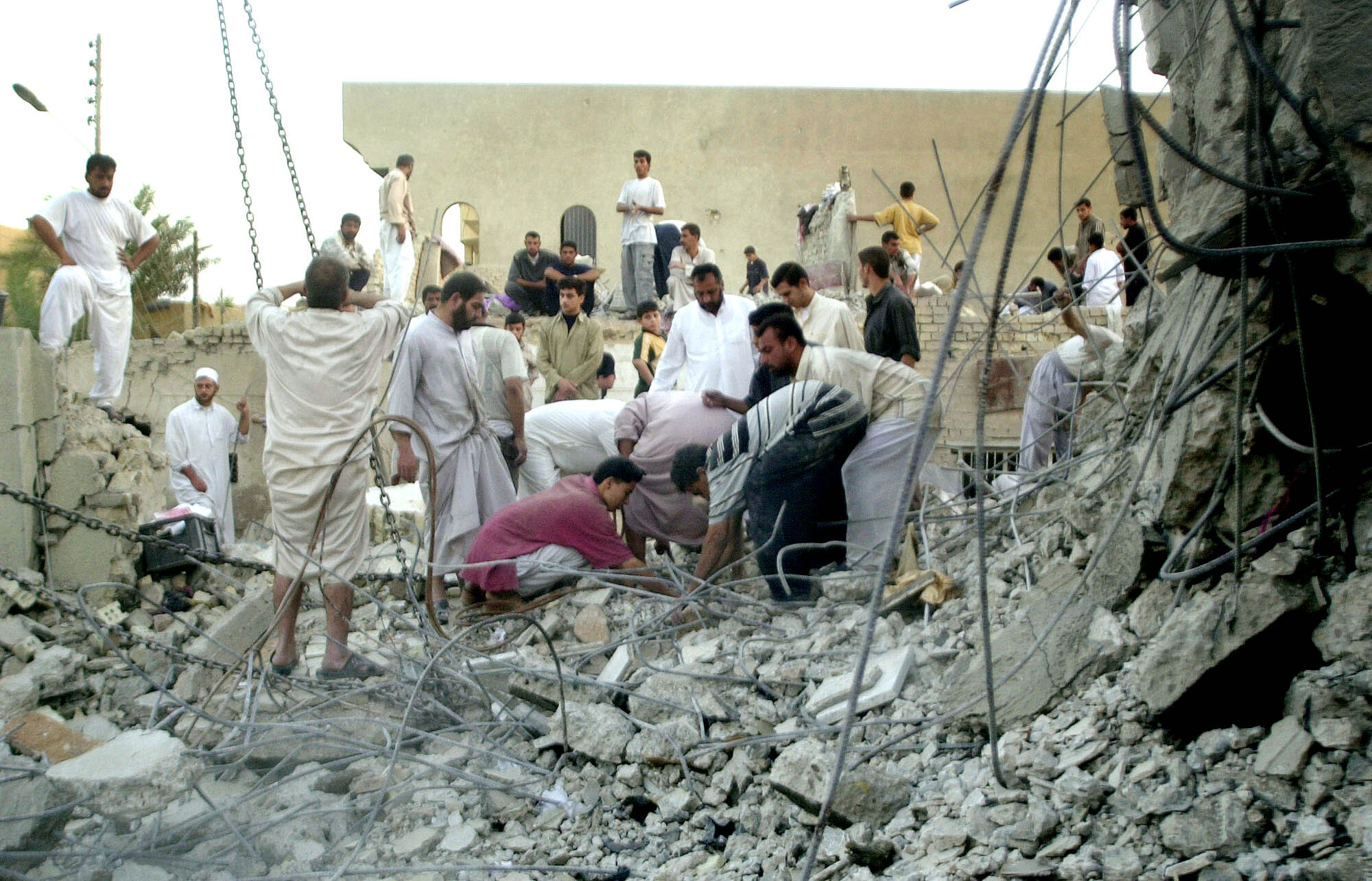 Residents stand amidst the debris of houses flattened in US air raids in Fallujah, Iraq.