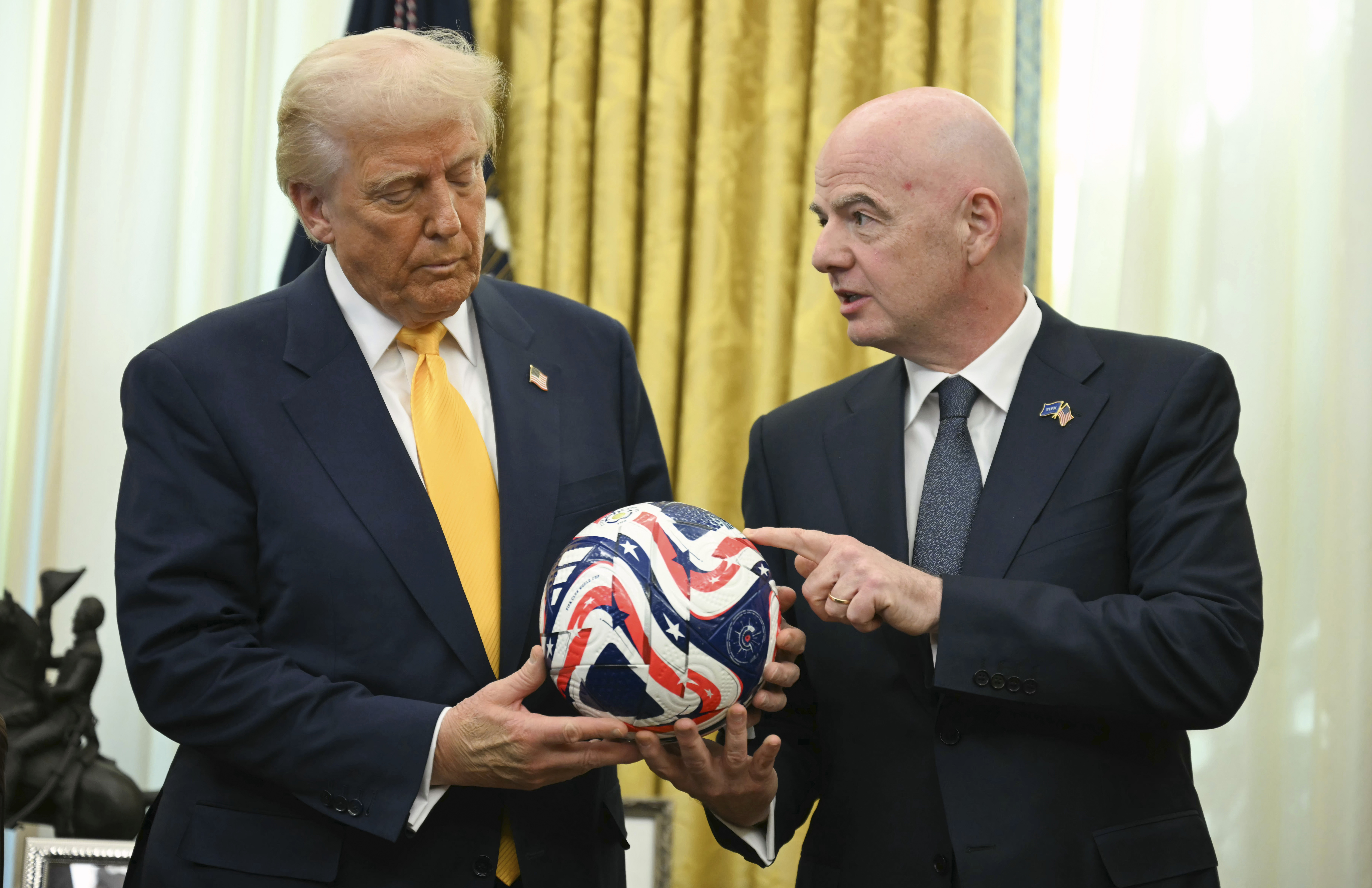 Trump holds a football with Gianni Infantino in the Oval Office.