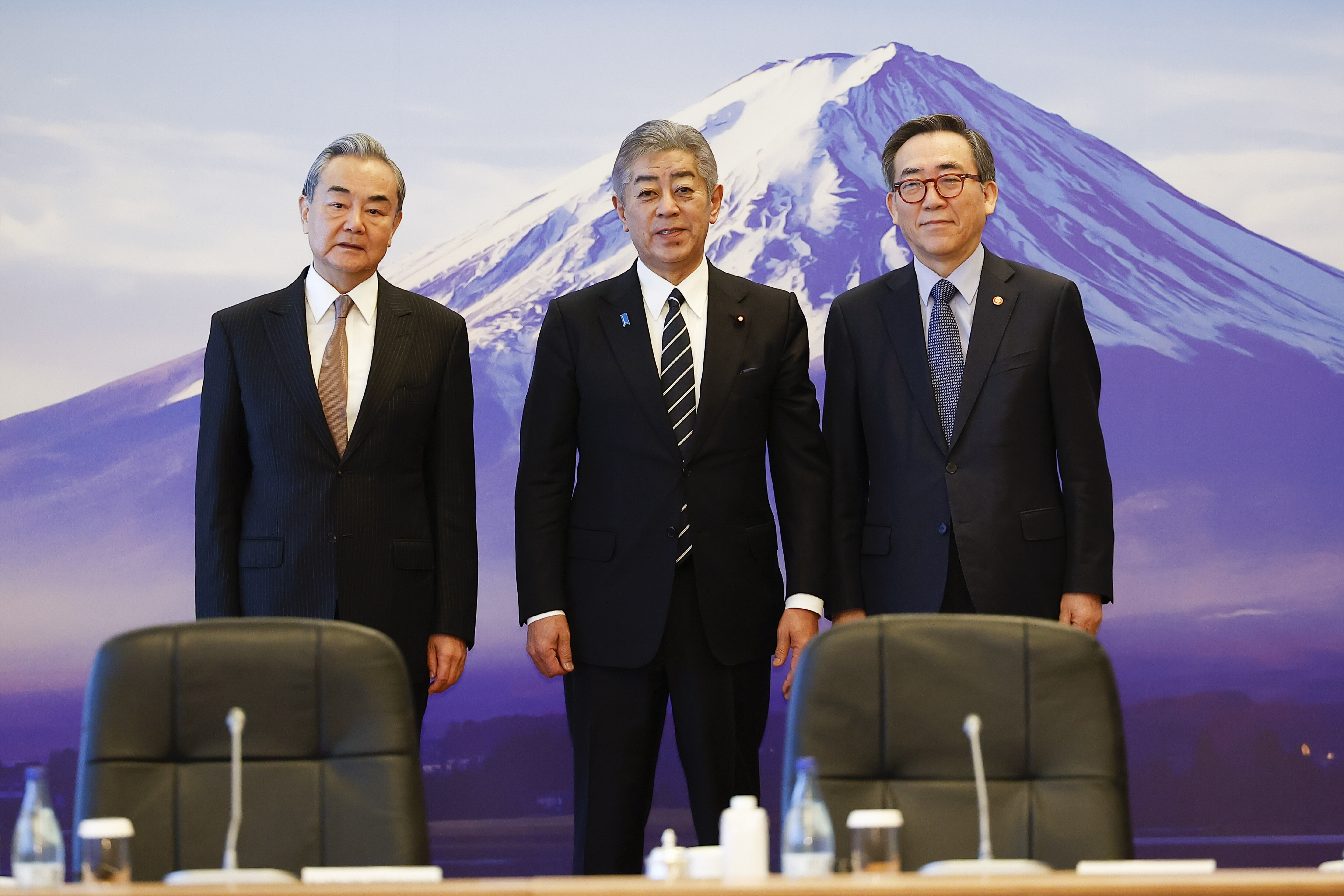 Japanese Foreign Minister Takeshi Iwaya, center, welcomes Chinese Foreign Minister Wang Yi and the South Korean Foreign Minister Cho Tae-yul