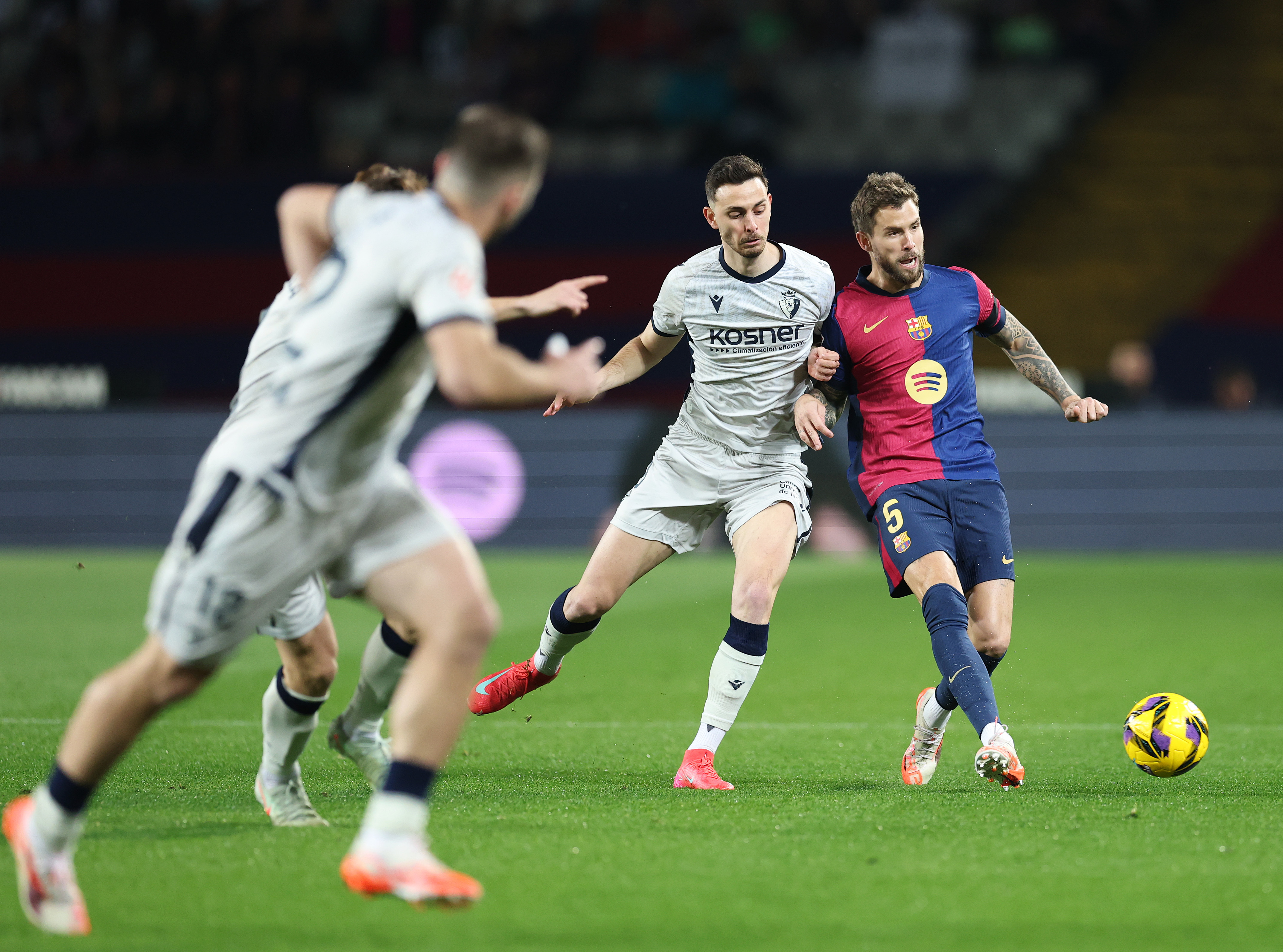 BARCELONA, SPAIN - MARCH 27: Inigo Martinez of FC Barcelona passes the ball whilst under pressure from Raul Garcia of CA Osasuna during the La Liga EA Sports match between FC Barcelona and CA Osasuna at Estadi Olimpic Lluis Companys on March 27, 2025 in Barcelona, Spain. (Photo by Clive Brunskill/Getty Images)