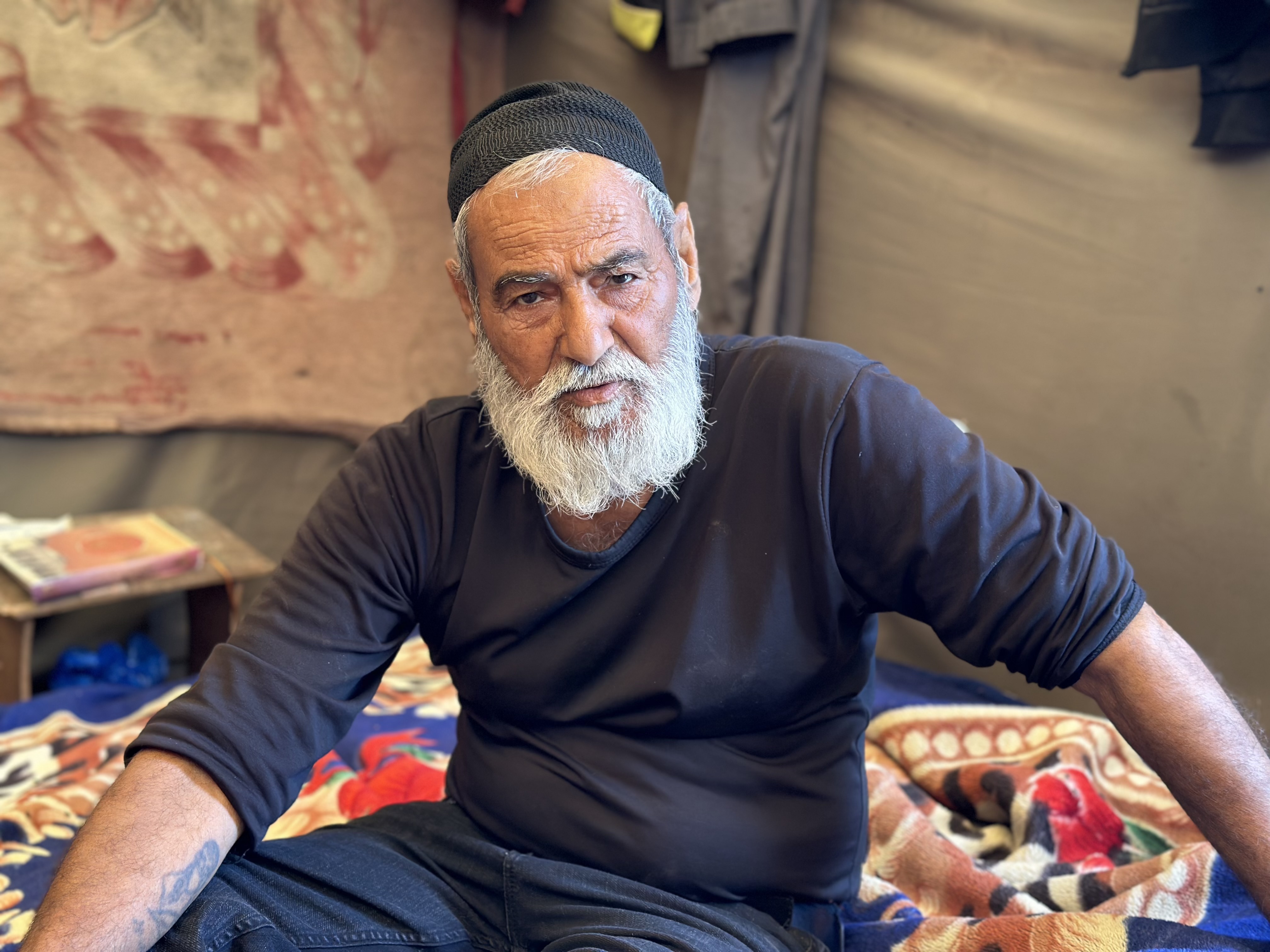 Bearded man sat down in a tent