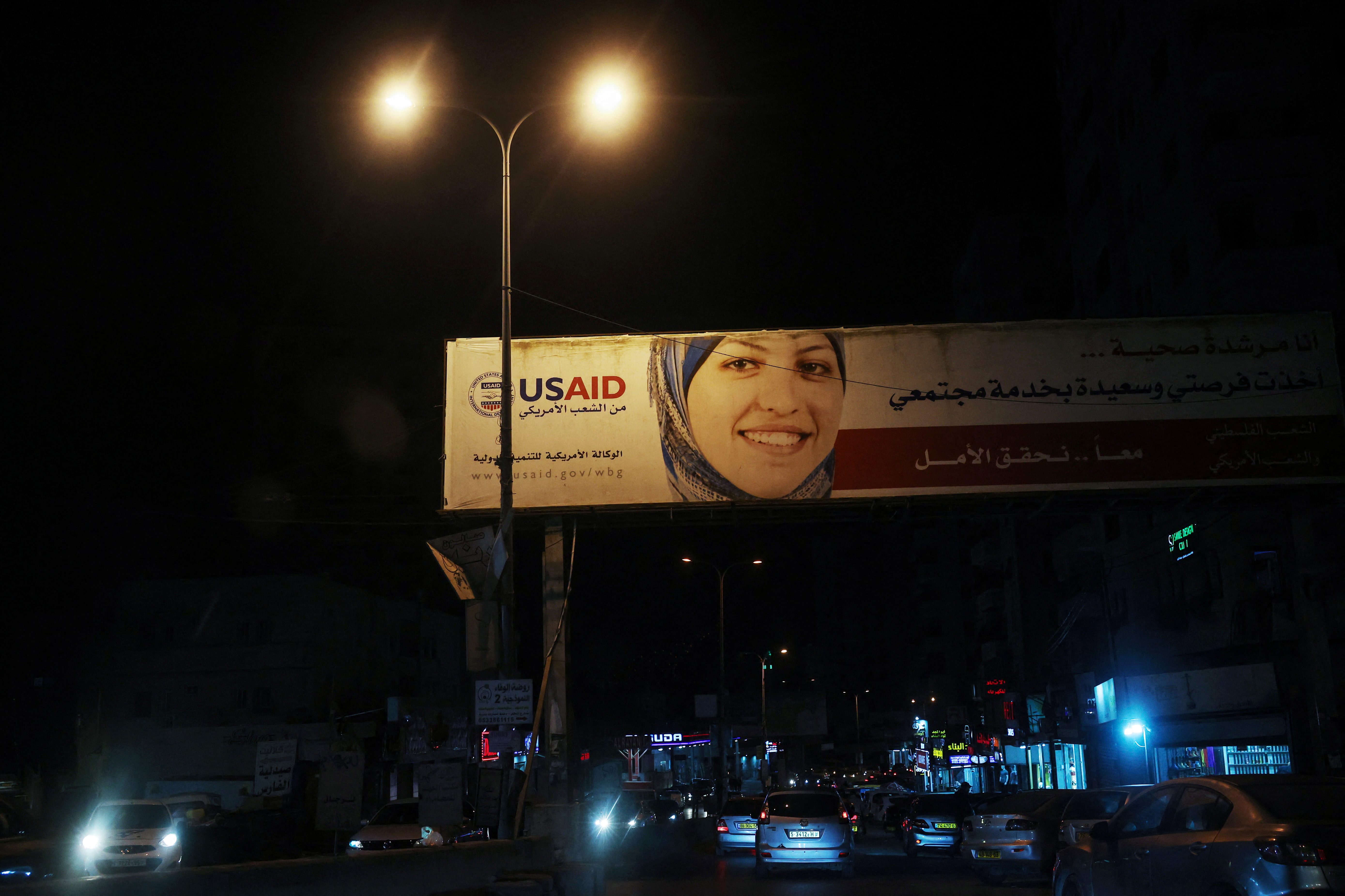 A billboard for the United States Agency for International Development group (USAID) stands by a road near a military checkpoint in the Israeli-occupied West Bank, May 3, 2024. REUTERS/Shannon Stapleton