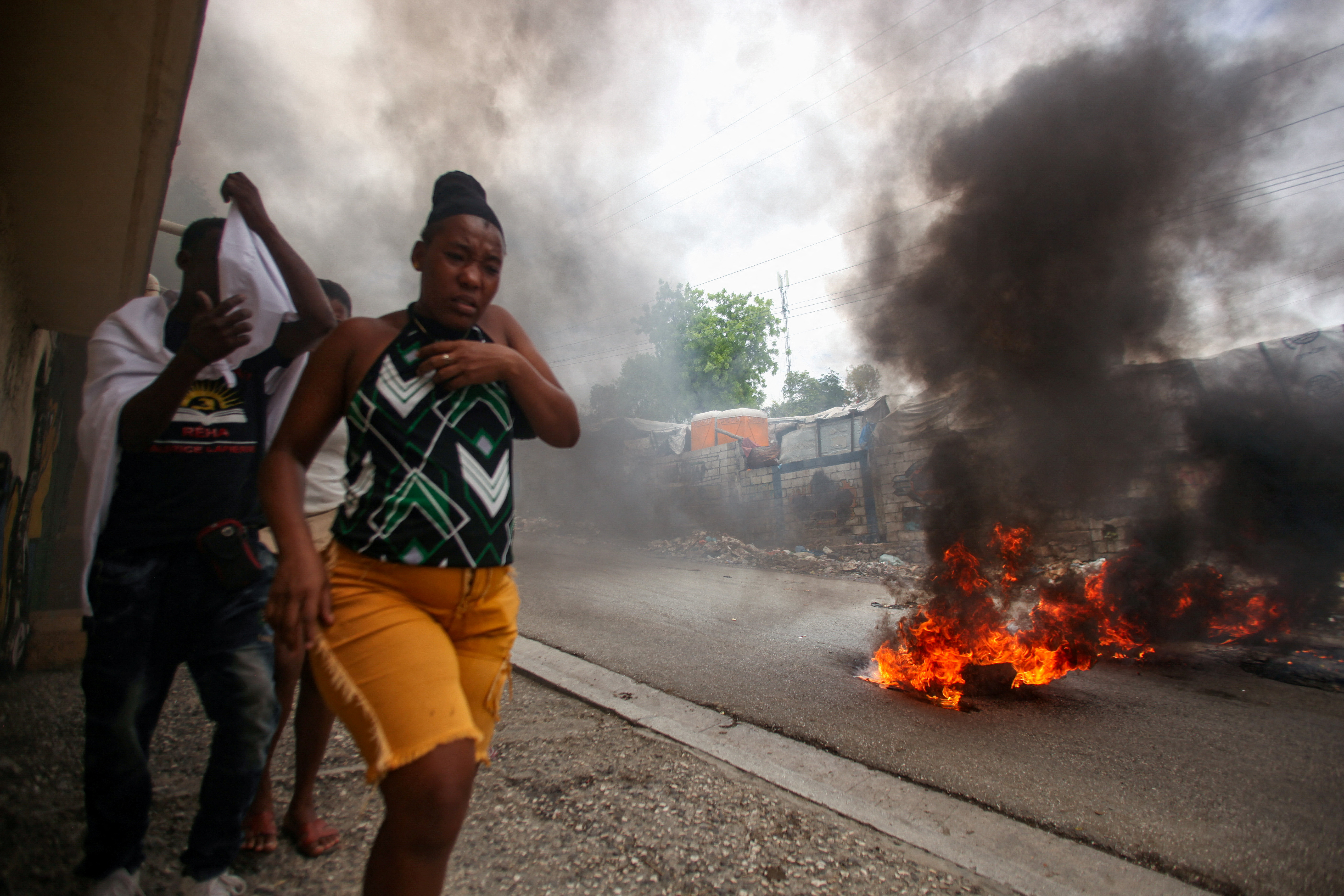 People walk past a burning barricade during a protest in Port-au-Prince, Haiti
