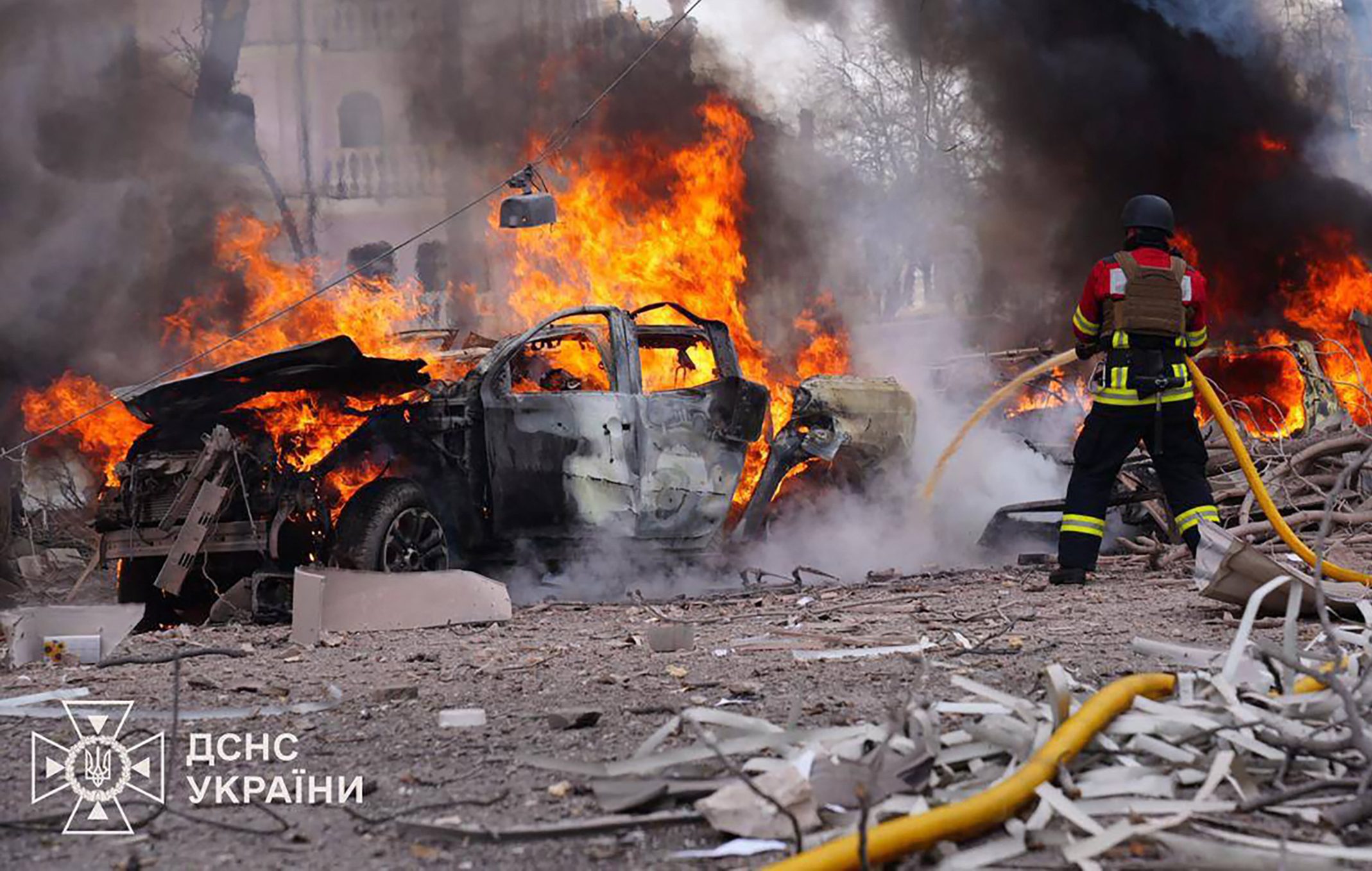 Ukrainian emergency responder works to extinguish a fire at the site of a missile attack in Sumy