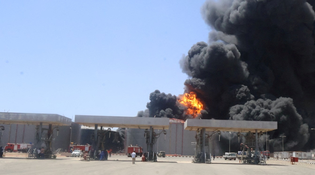 Large plumes of smoke and fire rising from fuel depot.