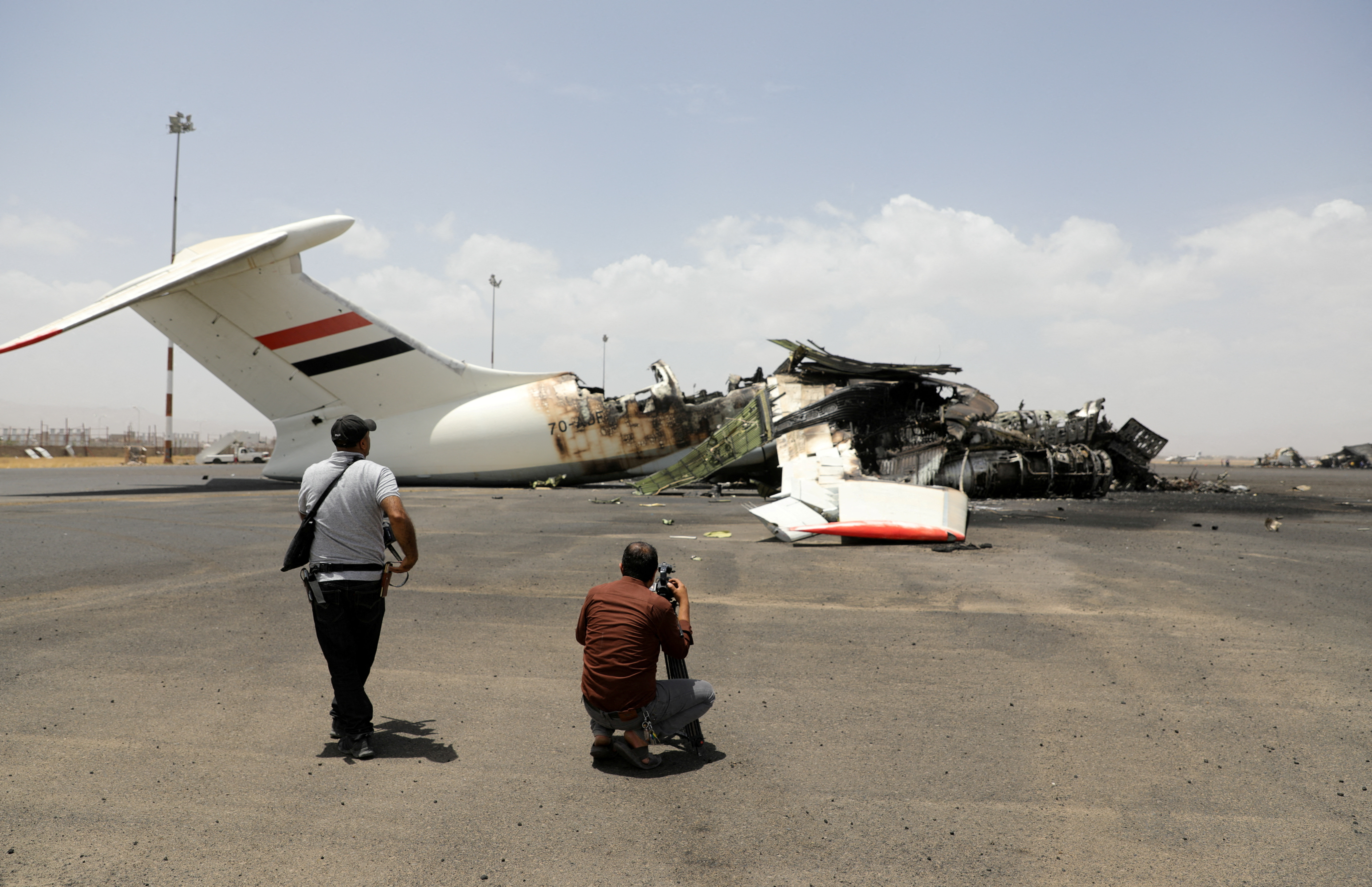 Members of the media take pictures of a destroyed plane.