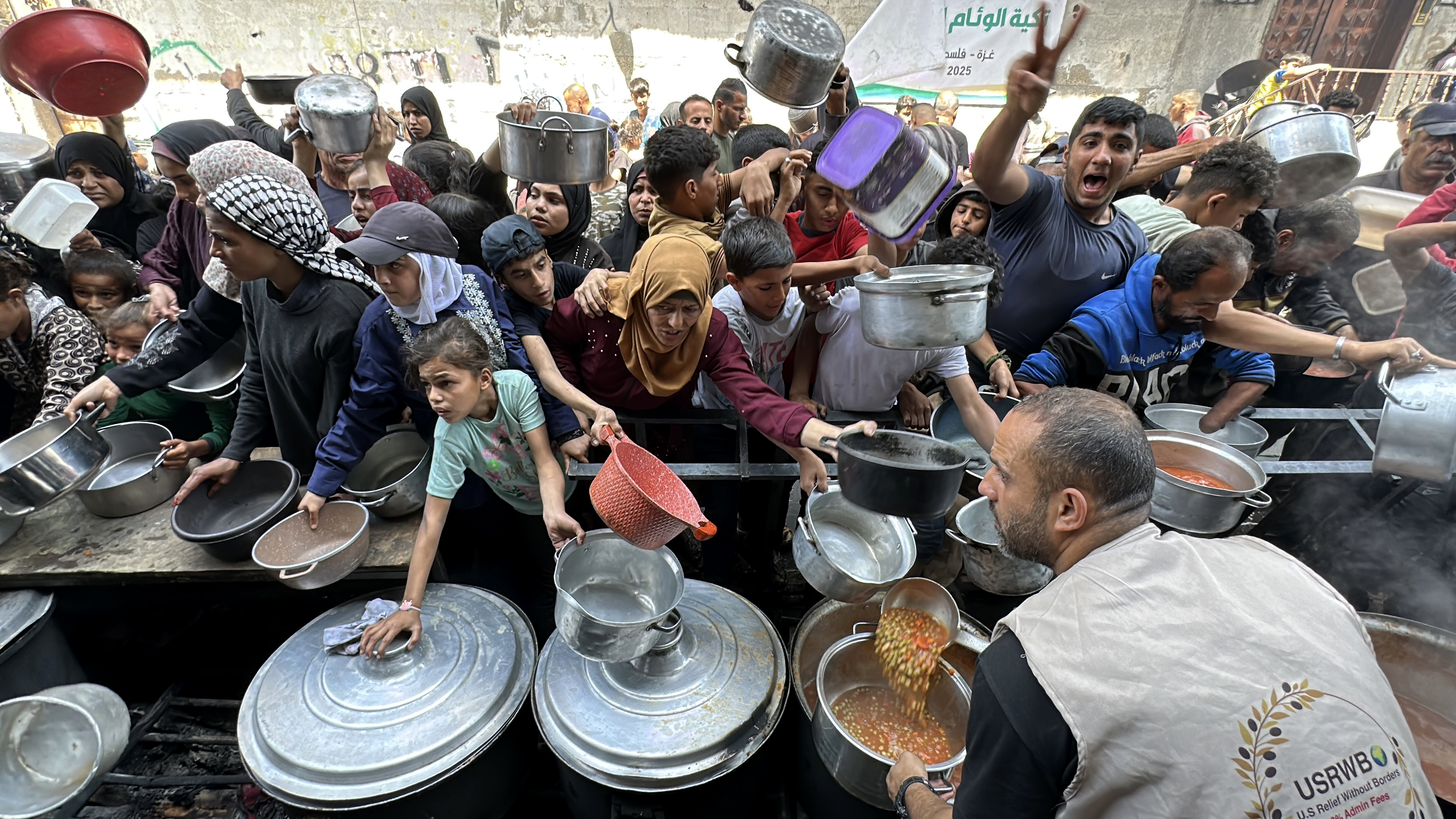 GAZA CITY, GAZA - MAY 01: Palestinians, mostly children, wait in long lines with empty pots in hands to get food aid distributed by the charity organizations in northern Gaza City, Gaza on May 01, 2025. In the Gaza Strip, where Israel has completely closed the border gates to humanitarian aid and continues its attacks, the food crisis continues. ( Karam Hassan - Anadolu Agency )