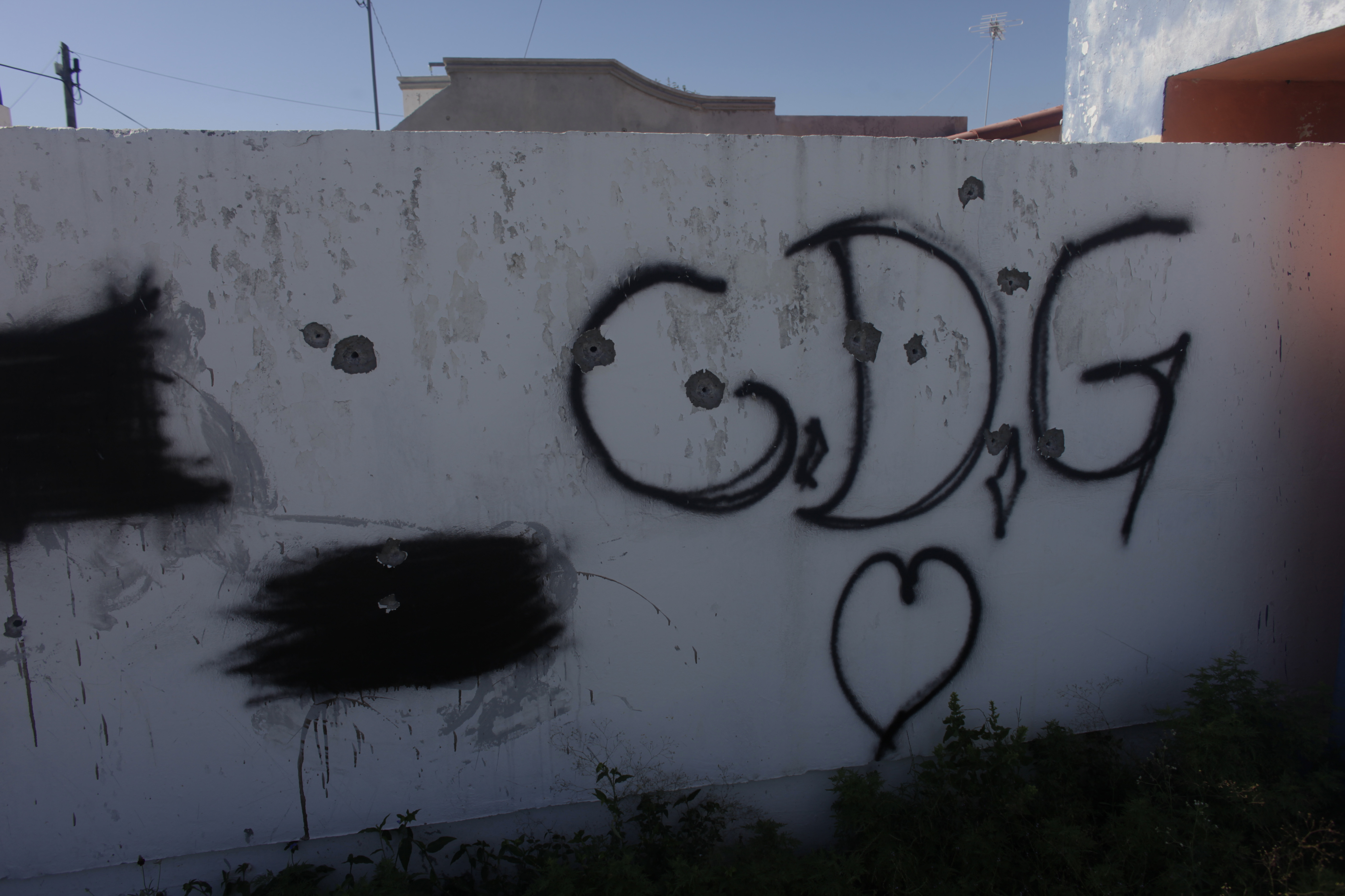 In this Friday Nov. 19, 2010 photo, initials of the Gulf Cartel (Cartel del Golfo) and a heart cover a wall at the entrance to an abandoned low-income housing complex in Ciudad Mier, Mexico. While Mexicans have been increasingly fleeing border towns up and down the Rio Grande valley, Ciudad Mier is the most dramatic example so far of the increasingly ferocious drug violence, and the government's failure to fight back. (AP Photo/Dario Lopez-Mills)